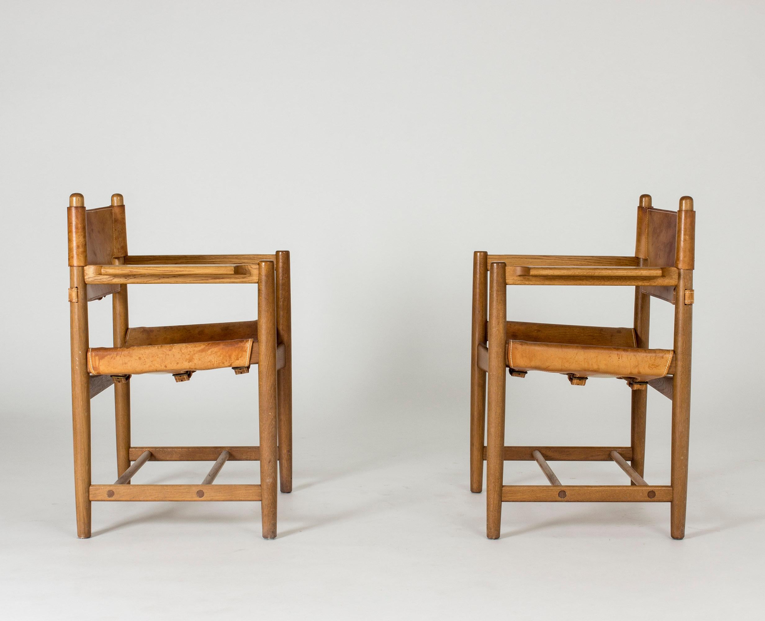 Pair of hunting chairs, model 3238, by Børge Mogensen. Made from oak and leather with accentuated white seams and buckles in the back. A great design, nicely aged.