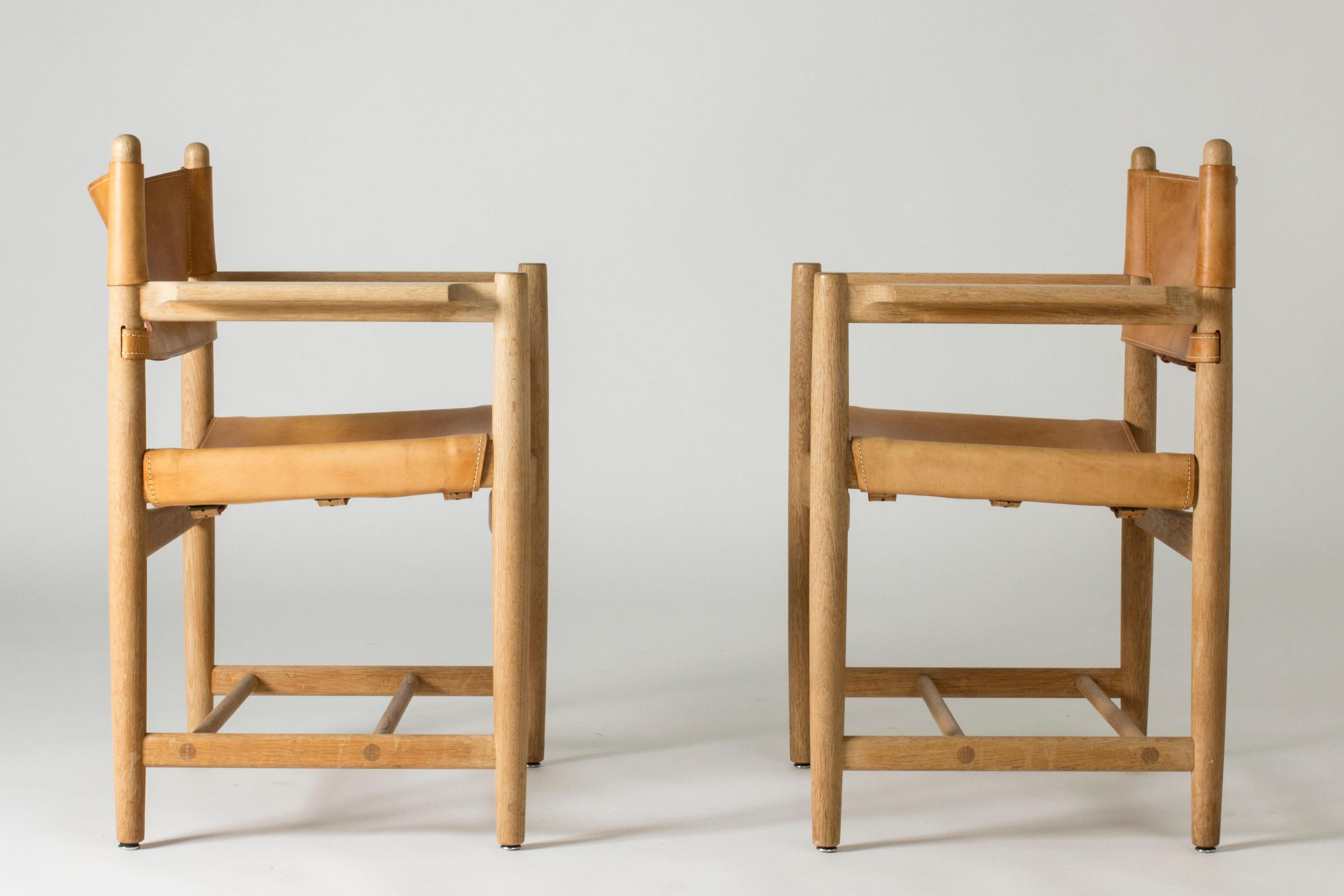 Pair of hunting chairs, model 3238, by Børge Mogensen. Made from oak and leather with accentuated white seams and buckles in the back. A great design, comfortable to be seated in.