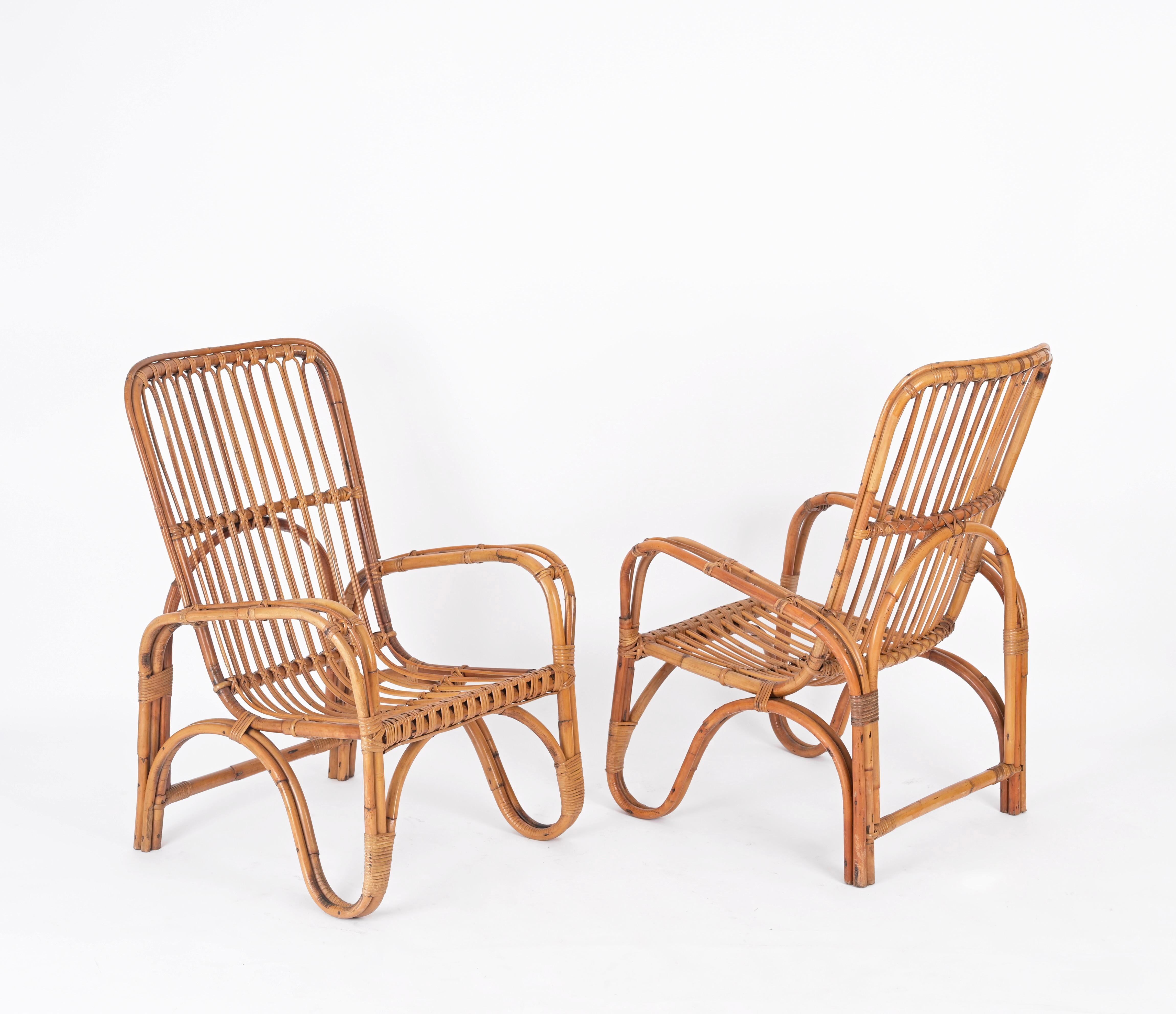 Fantastic pair of Mid-Century French Riviera style armchairs fully made in curved rattan, bamboo and hand-woven wicker. These lovely armchairs were designed in Italy during the 1960s and are attributed to Tito Agnoli.

The armchairs are in fantastic