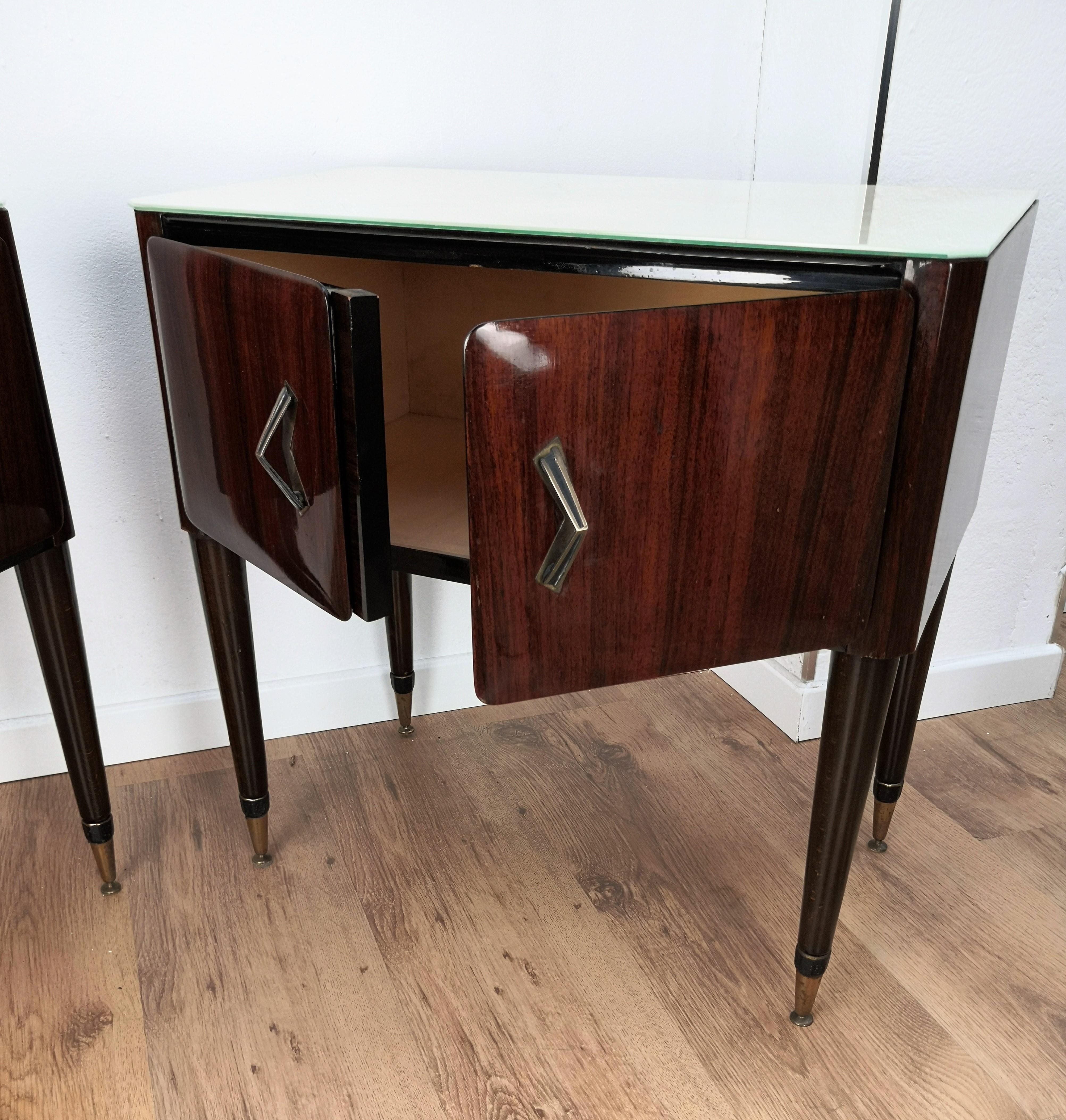 Very elegant and refined Italian 1950s Mid-Century Modern, neoclassical, in typical Art Deco design, pair of bedside tables with wood double front door, marble glass top and brass details such as the 2 handles and the 4 foot ends. Those pieces, in