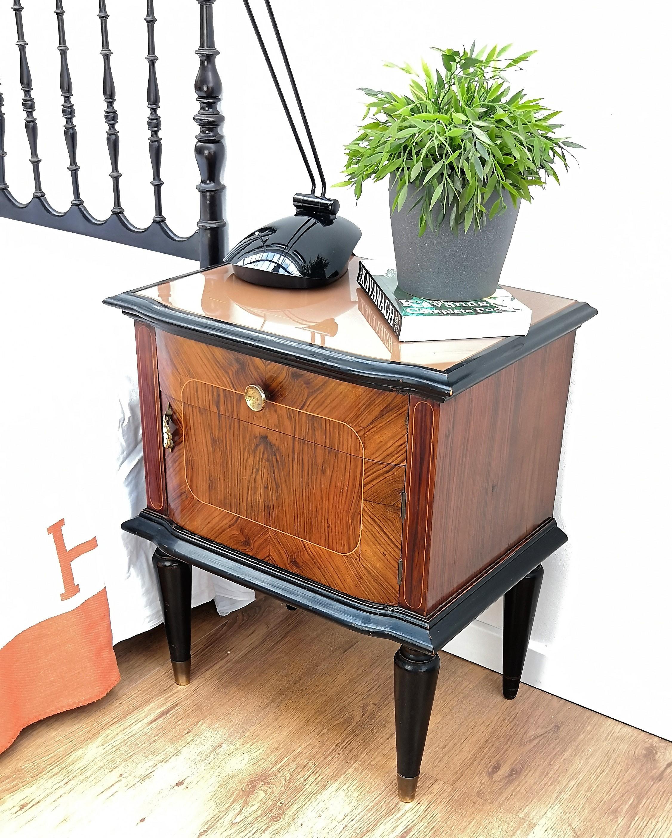 Very elegant and refined Italian 1950s Mid-Century Modern, neoclassical, in typical Art Deco midcentury design, pair of bedside tables in great walnut wood veneer craftmanship and inlay gilt decors with front top half drawer and half door, lacquered