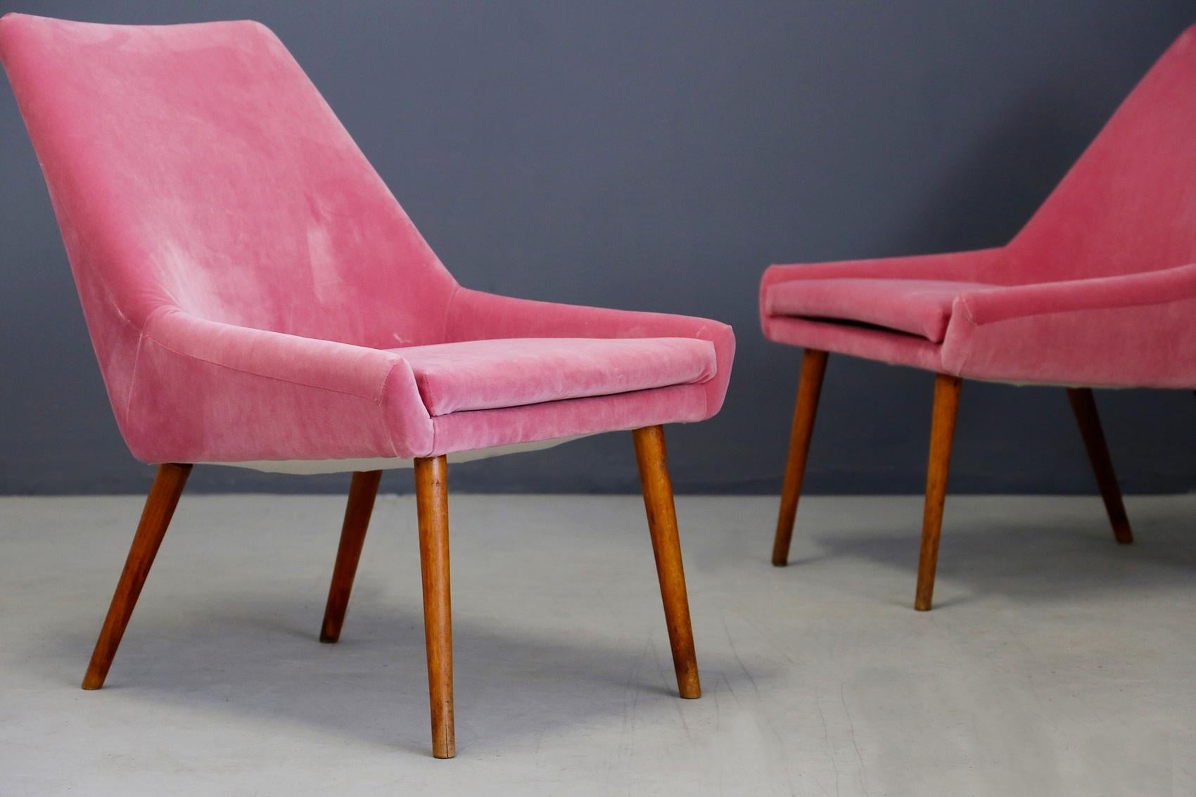 Pair of midcentury armchairs attributed to Italian designer Carlo Pagani from 1950. The armchairs have been restored and lined in pink velvet. Note the very long conical feet that give the seat a beautiful line. The peculiarity of the two armchairs
