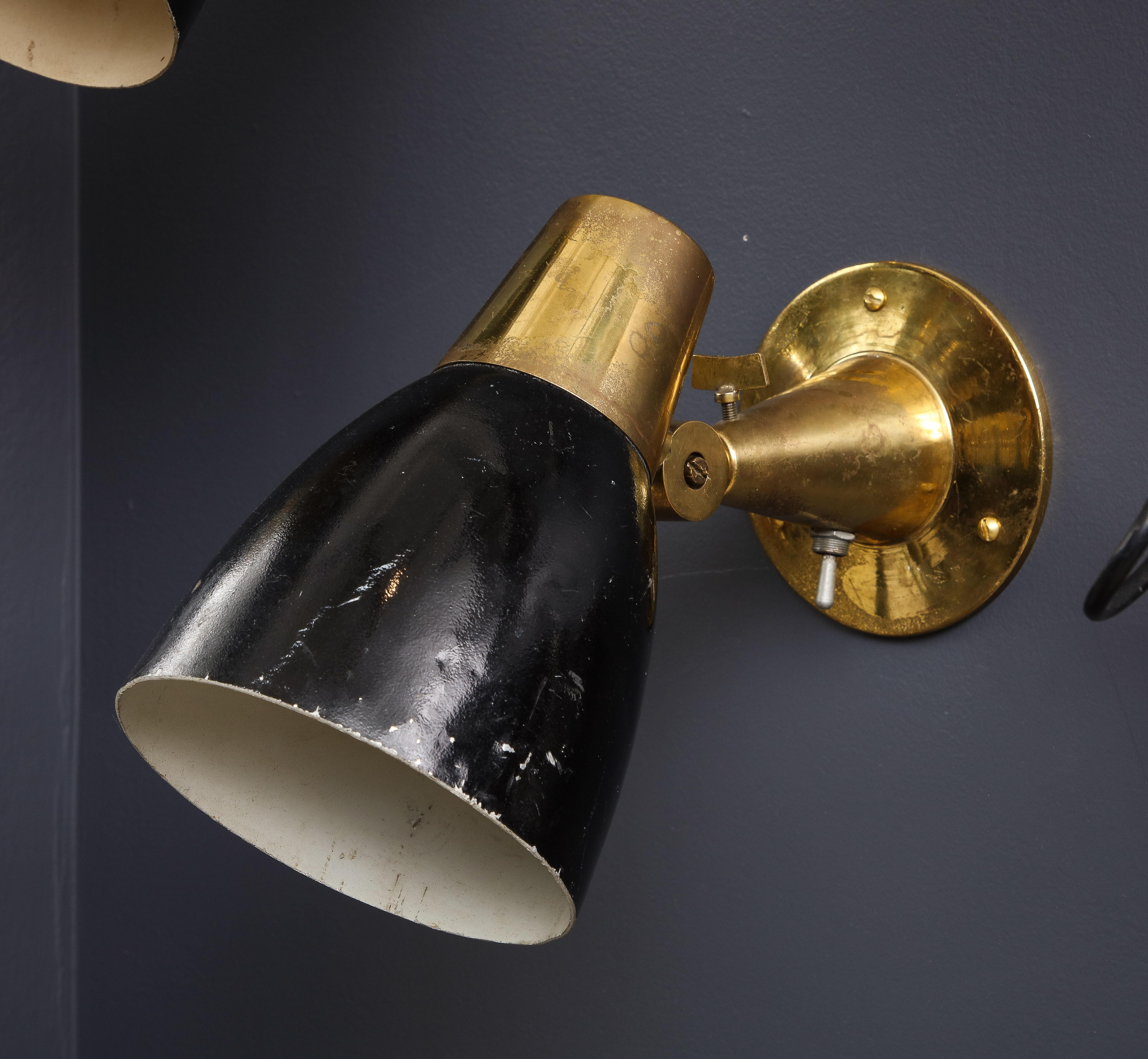 A rare and elegant pair of Italian mid-century wall lights in the style of Oscar Torlasco for Stilux, 1950s. Beautiful brass details with original switch and screw functional. Steel shades are painted in black enamel, price includes repainting of