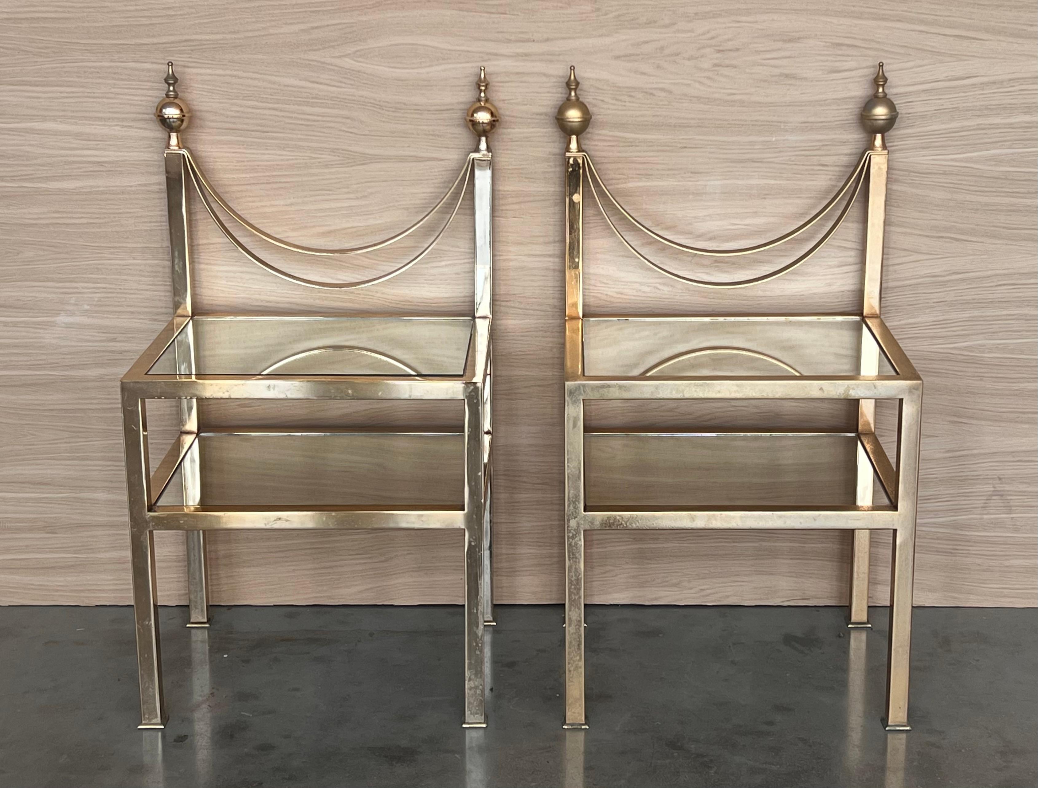 Pair of midcentury Italian two tier brass and glass nightstands with crest.
Simple tables with a low grid shelve and glass top. 

Height to the glass top :18.70in.