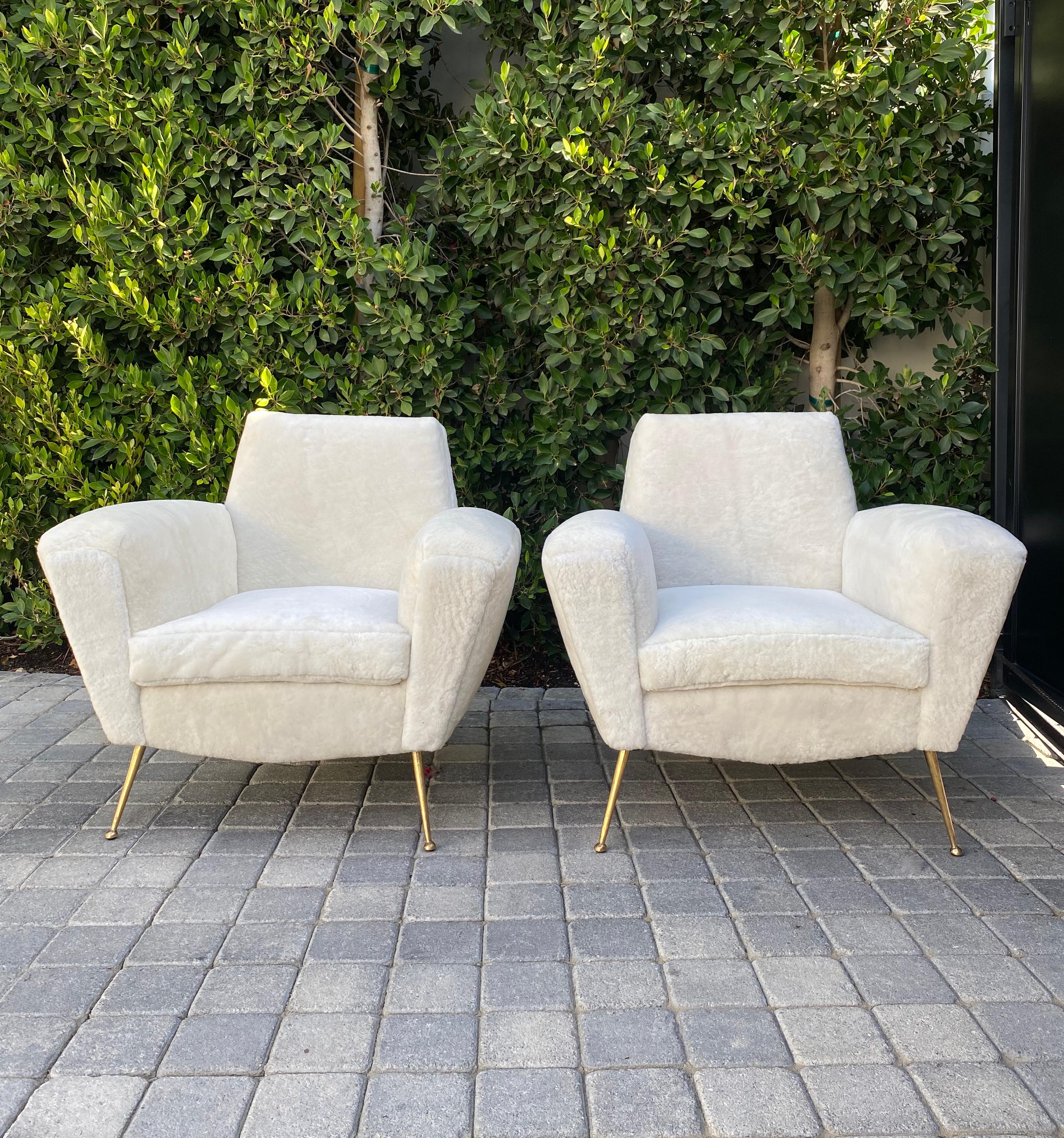 Pair of midcentury Italian club chairs in white Shearling similar to Lenzi 548 reimagined with solid brass leg detail.