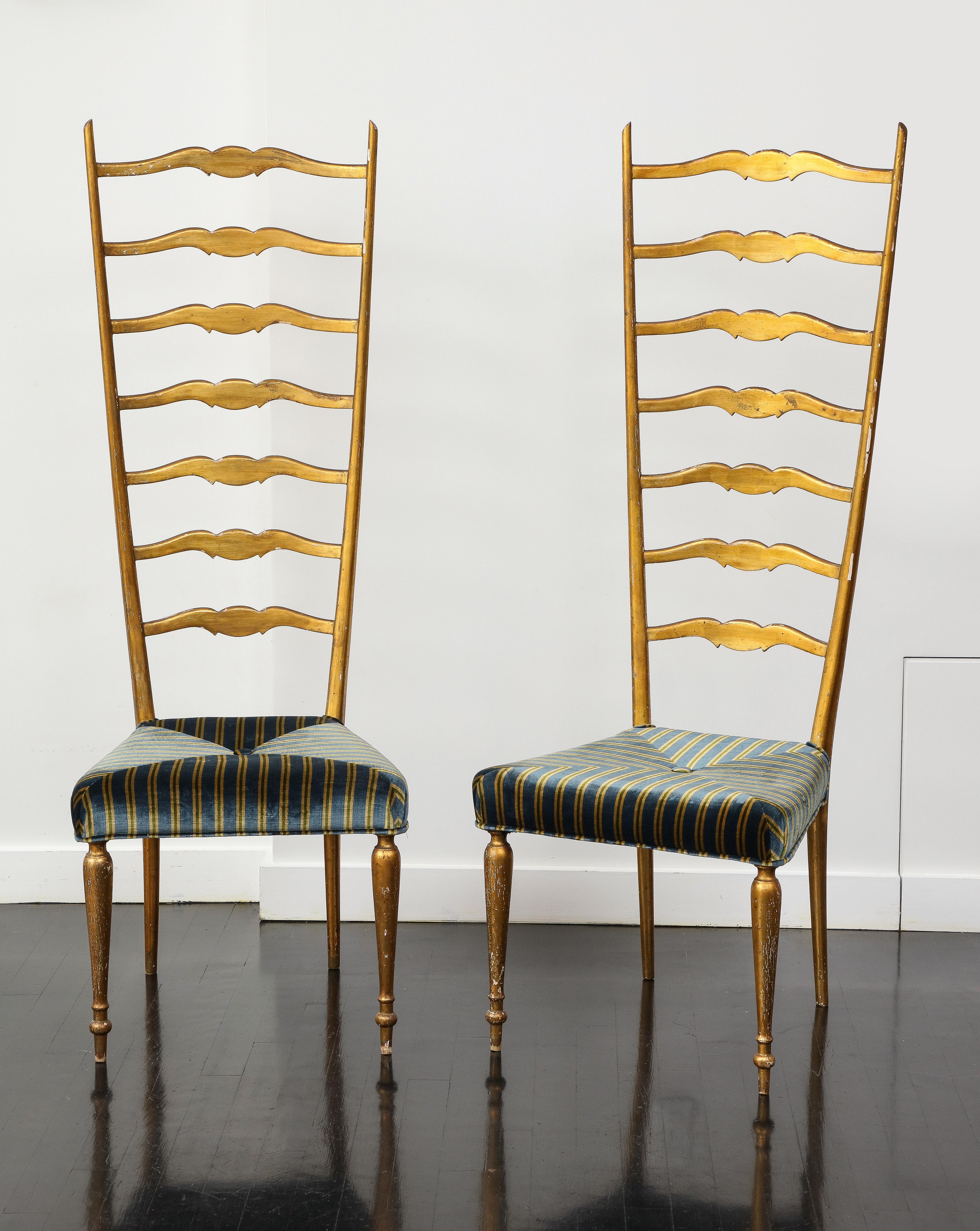 Pair of midcentury Italian giltwood exaggerated high ladder back side chairs, with recently upholstered striped velvet seats featuring a single button in the center. Scrolling accents add elegance to the ladder back, the chair rests on cylindrical