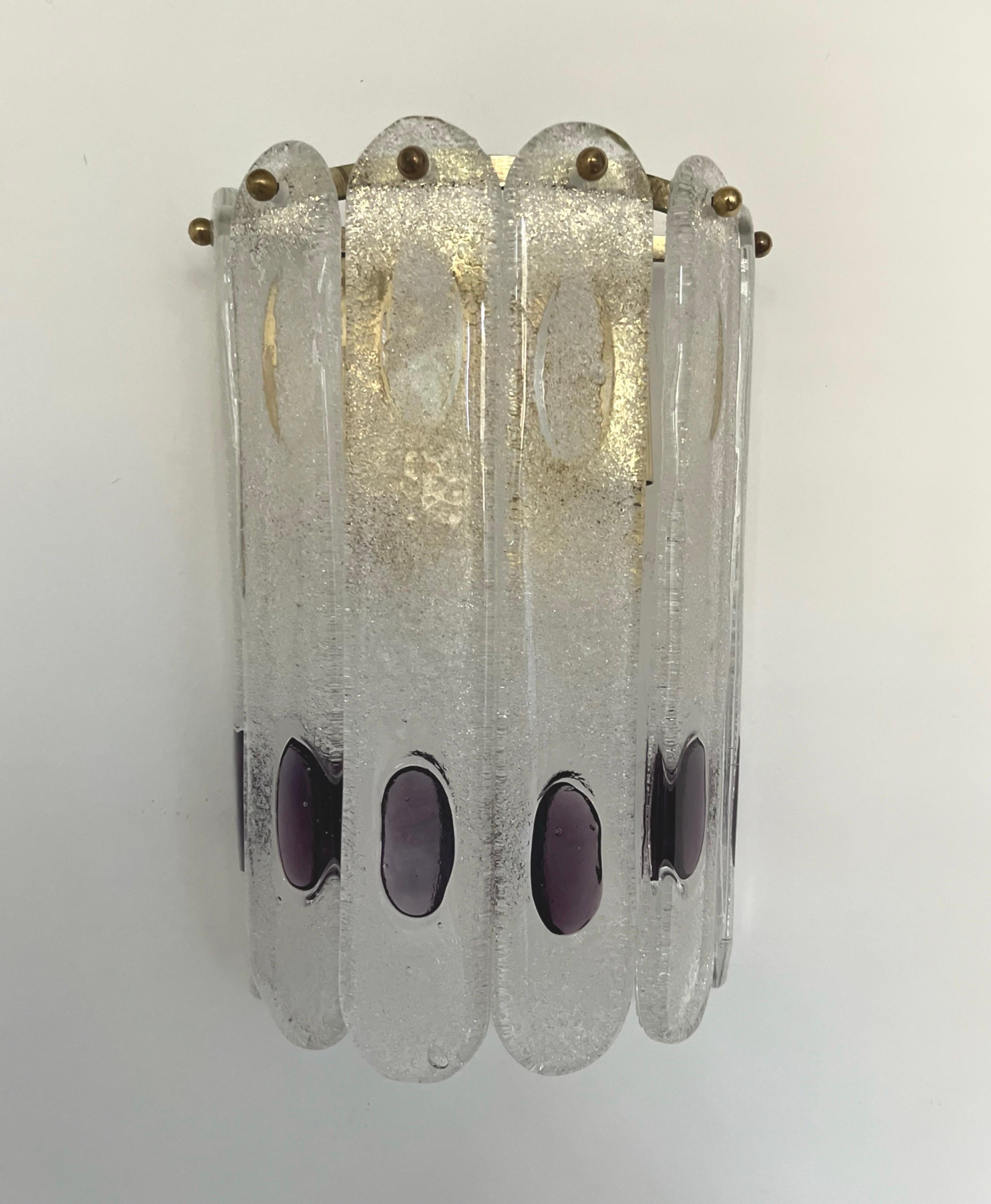 Marvelous and unique Pair of Italian Clear Lilac murano glass Wall Sconces from 1970s. These fixtures were designed and munufactured during the 1970s in Italy by Mazzega. 
Each sconce is equipped with two light sockets E27. A professional