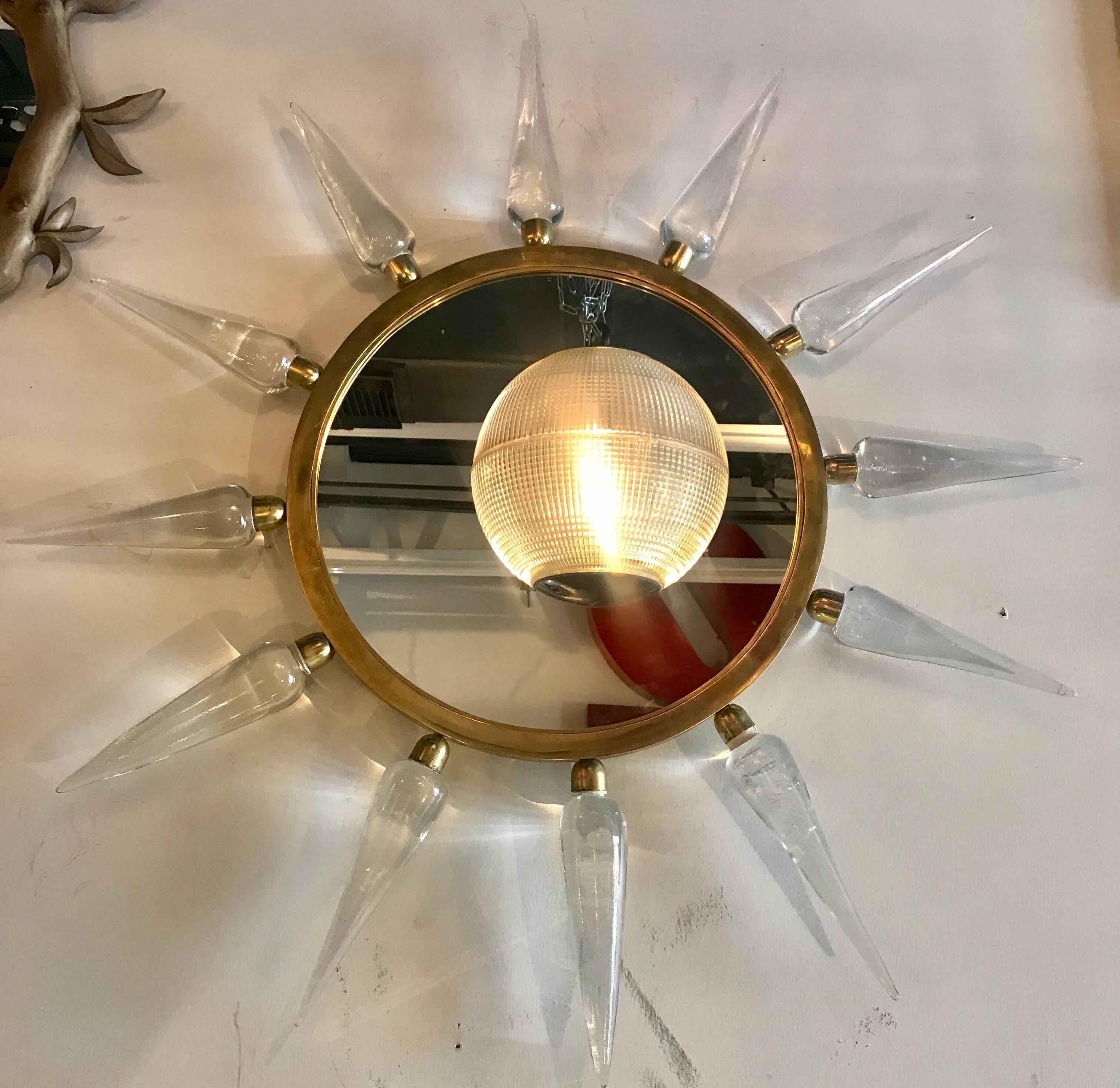 A pair of midcentury Italian sun mirrors with thick Murano glass spikes and brass hardware.