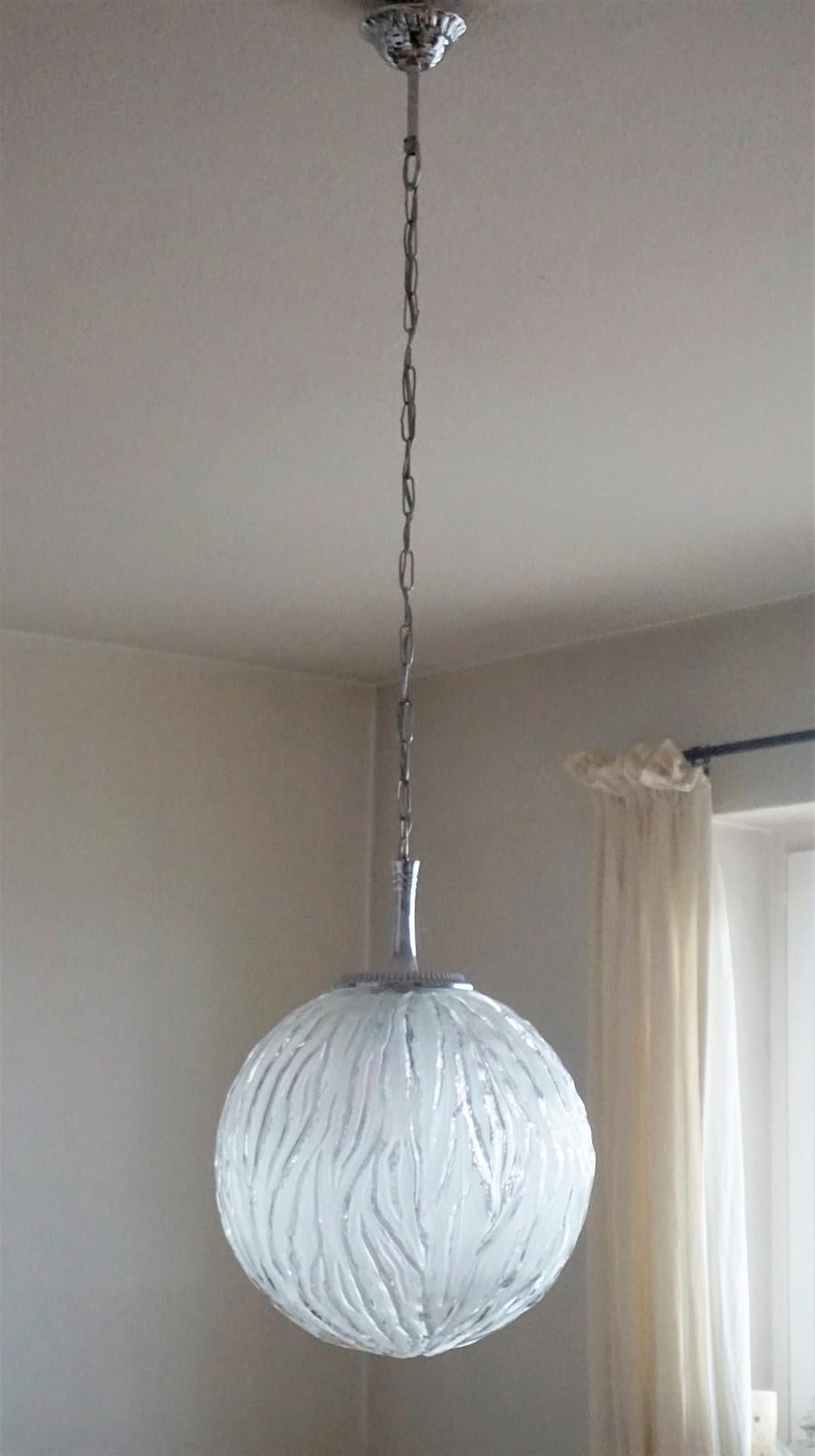 Paire de pendentifs ou de lanternes en forme de sphère en verre de style Degue avec des montures chromées, France, années 1950.
Une douille Edison E27 pour une ampoule de grande taille jusqu'à 100W
les deux pendentifs sont en très bon état, refaits