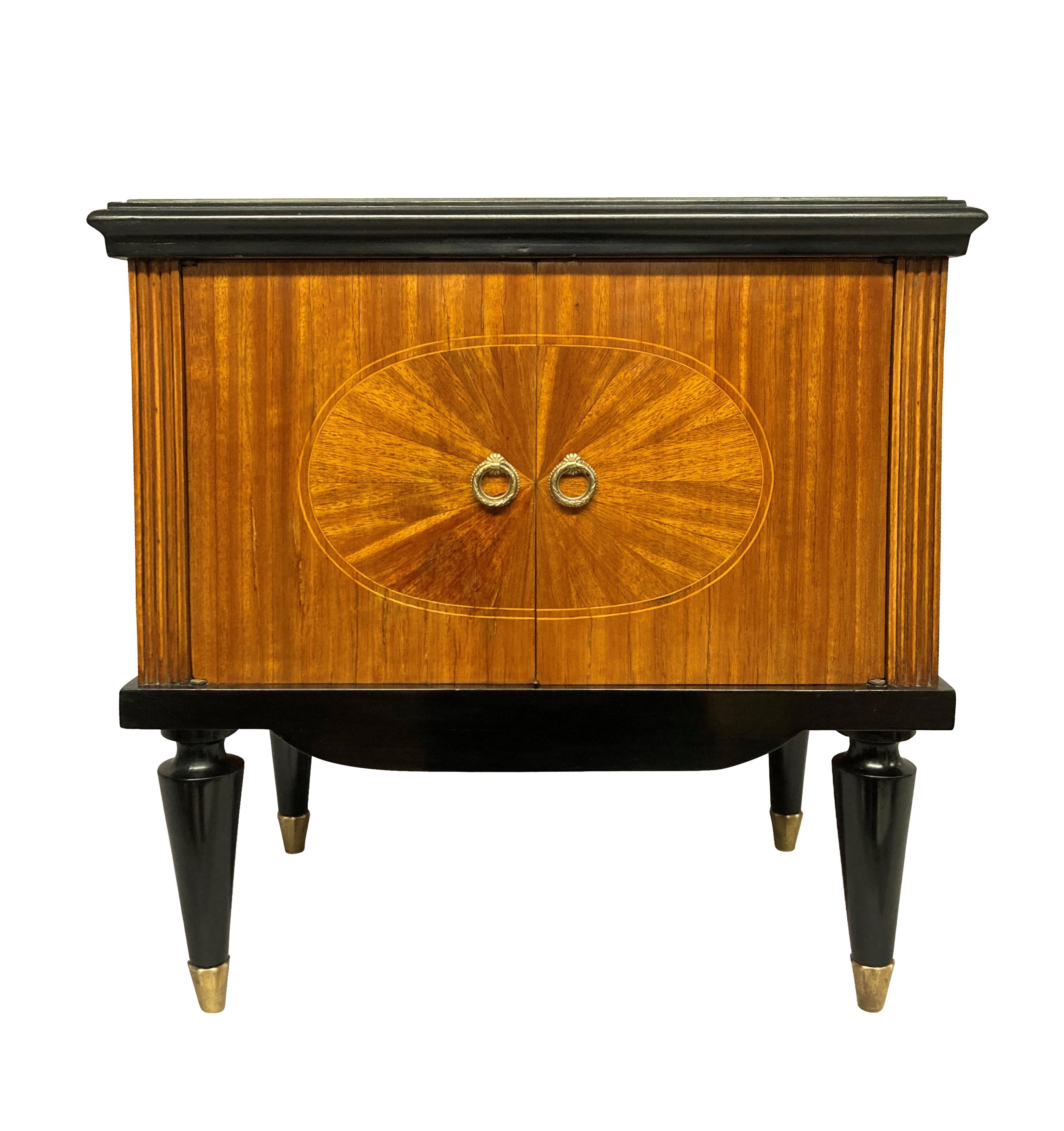 A pair of fine Italian Mid-Century night stands, finely veneered, with ebonised detailing throughout. With two doors and a cupboard inside, brass sabot and champagne coloured glass tops.