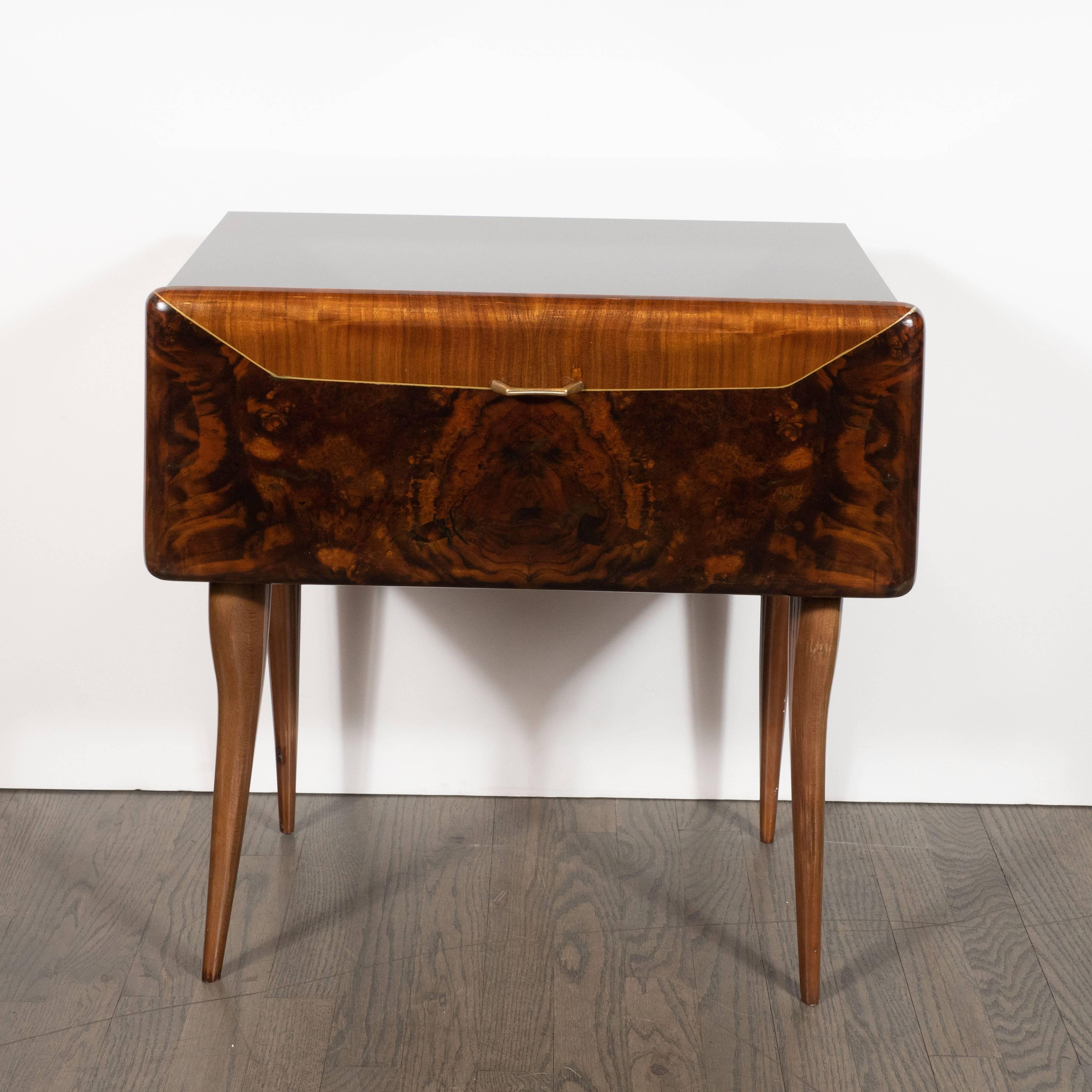 This sophisticated pair of nightstand/ end tables were realized in Italy, circa 1950. They feature black vitrolite tops; a drop front drawer with bookmatched inlays of burled walnut and zebra wood with a holly inlay. Additionally, each piece offers