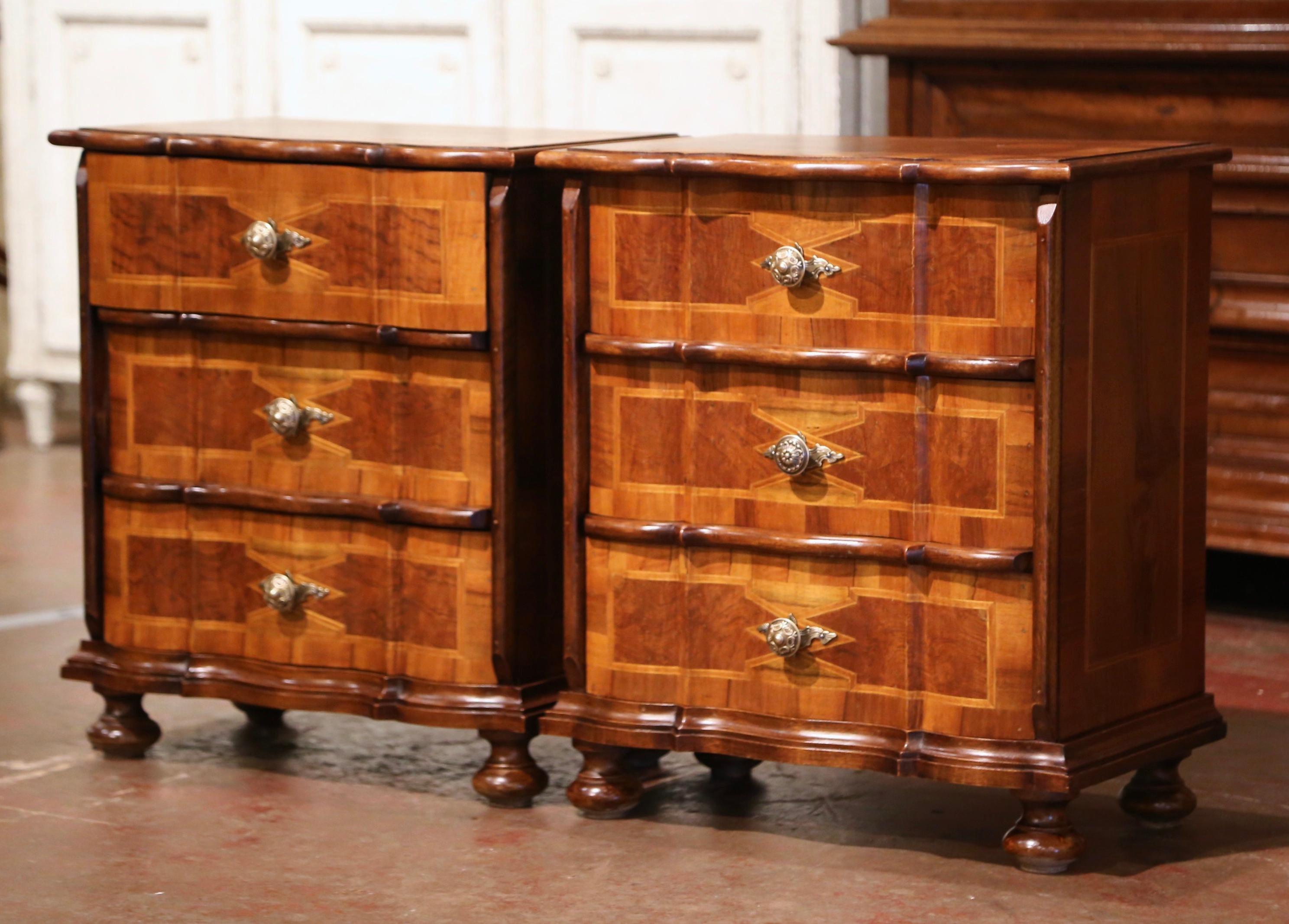 Decorate a master bedroom with this elegant pair of Venetian nightstands; crafted in Italy circa 1970, each chest stands on bun feet over a scalloped apron, and features three serpentine drawers embellished with contrasting string inlay, and dressed