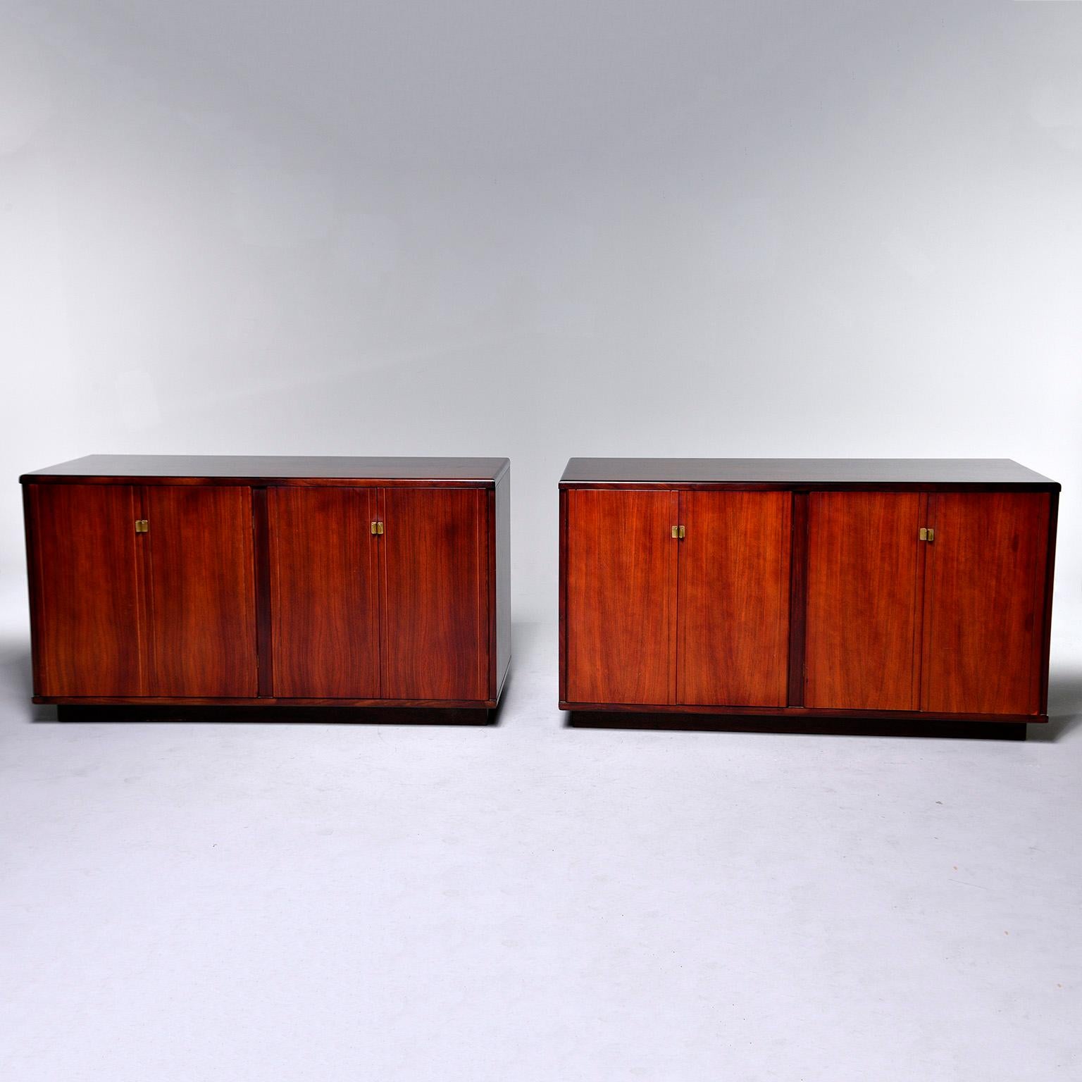 Pair of circa 1960s Italian rosewood cabinets. Each cabinet features two storage compartments with a single interior shelf and hinged doors with streamlined brass hardware. Unknown maker. Sold and priced as a pair.
 