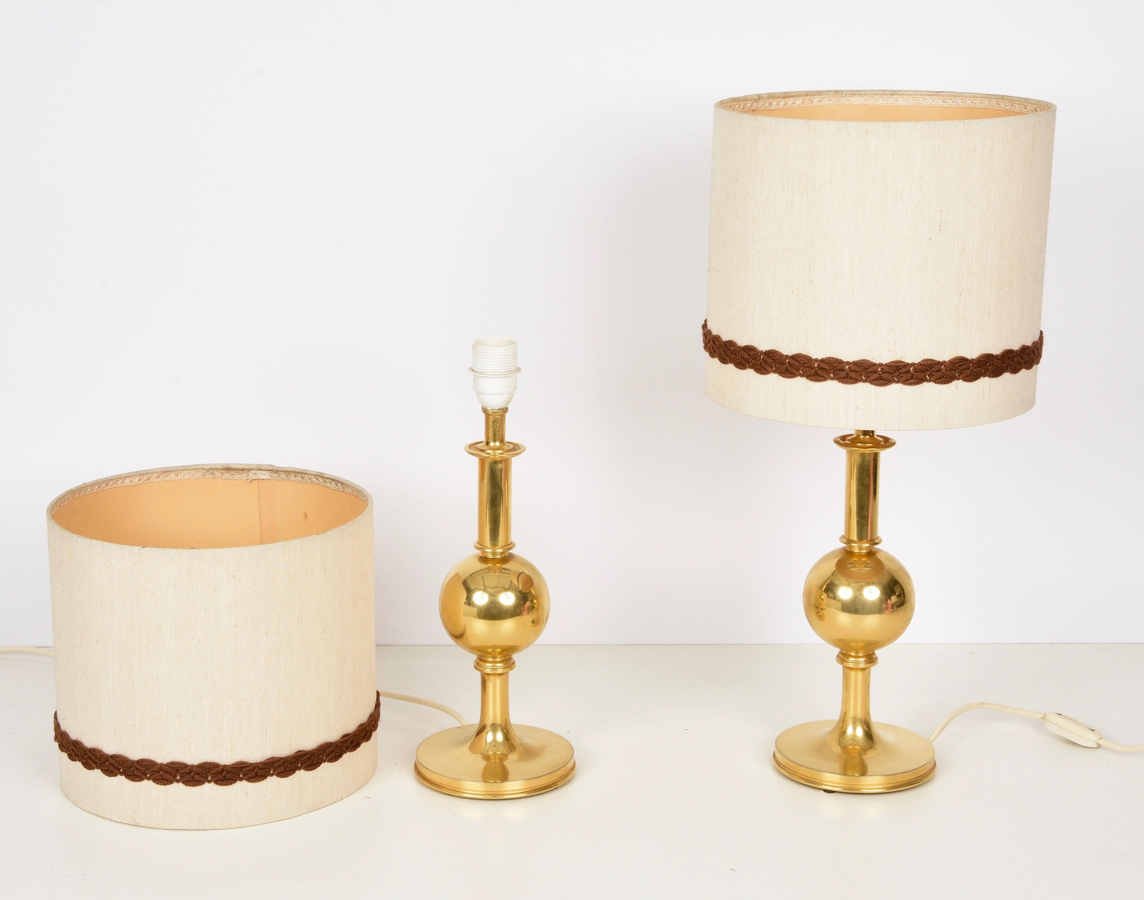Midcentury 24K gold solid brass table lamps. These fantastic lamps were produced in Italy during the 1980s

You are going to love the solid structure and the mix of cylindrical, in the top and the bottom, and spherical parts and they both mount a