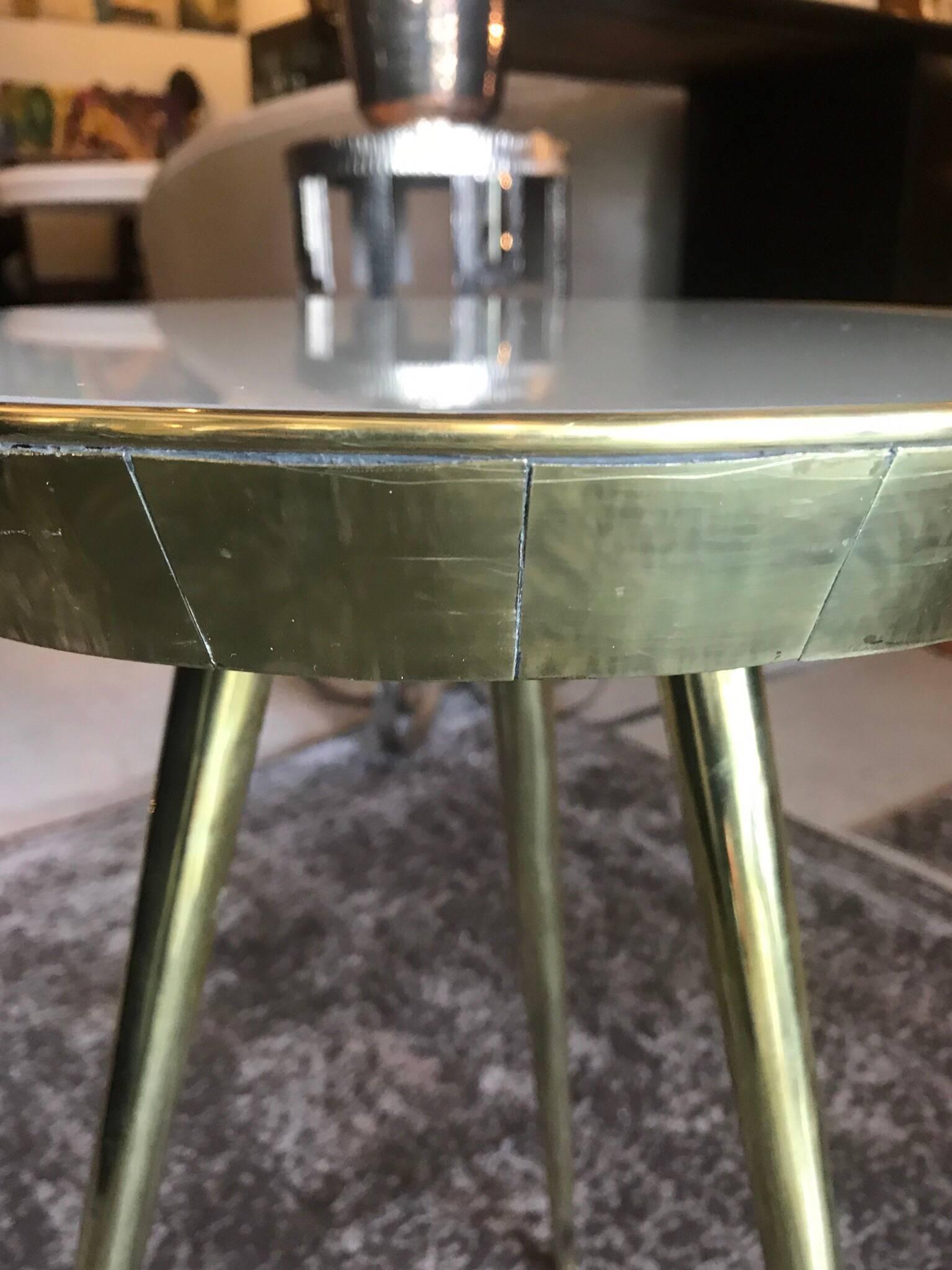 A pair of sleek Italian taupe colored glass tops and tripod brass legged side tables.