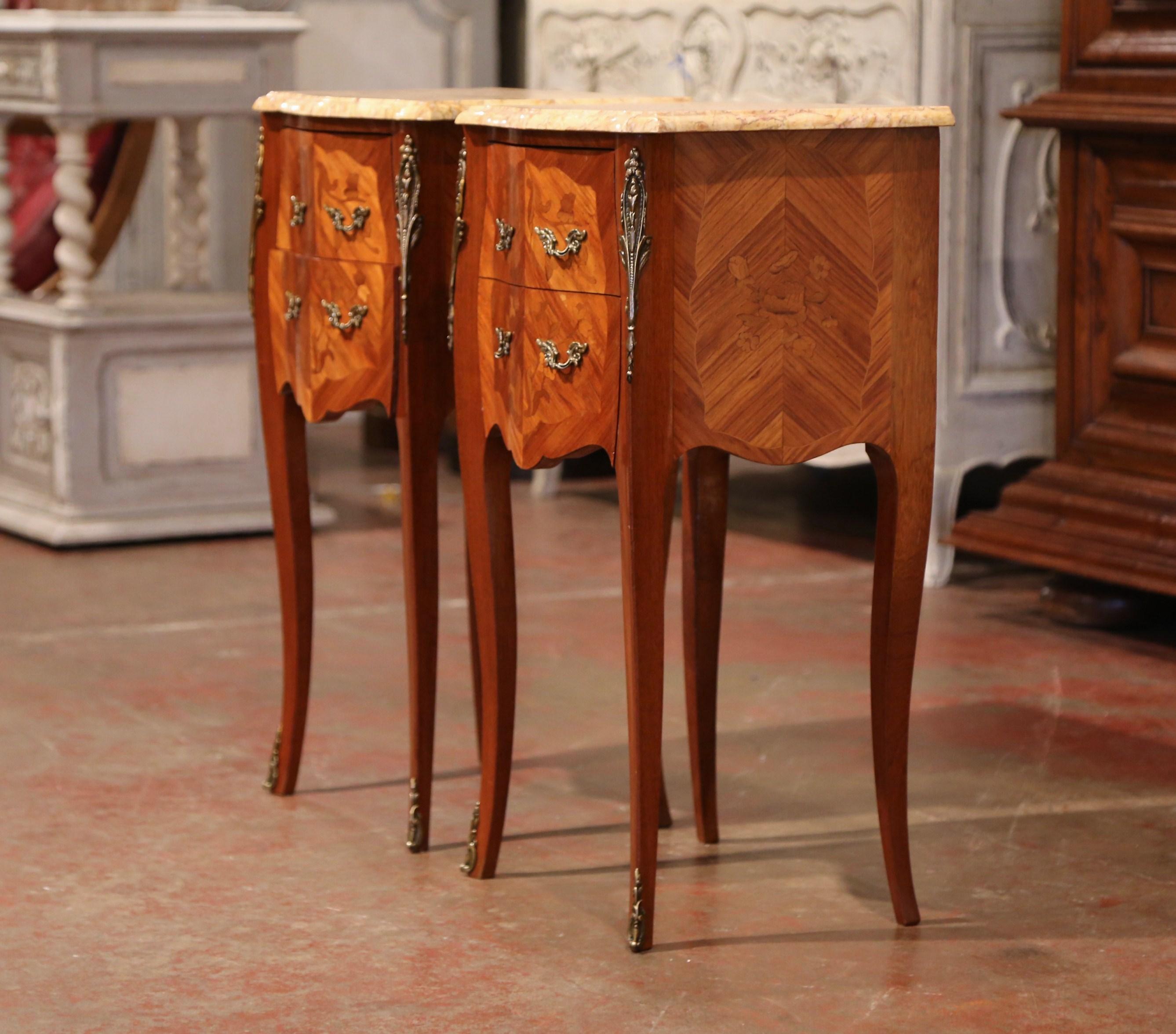 These elegant bedside tables were created in France, circa 1950. Bombe in shape on all three sides, the fruitwood cabinets stand on long cabriole legs with decorative brass sabot feet; both sides with serpentine shape have an inlay veneer chevron
