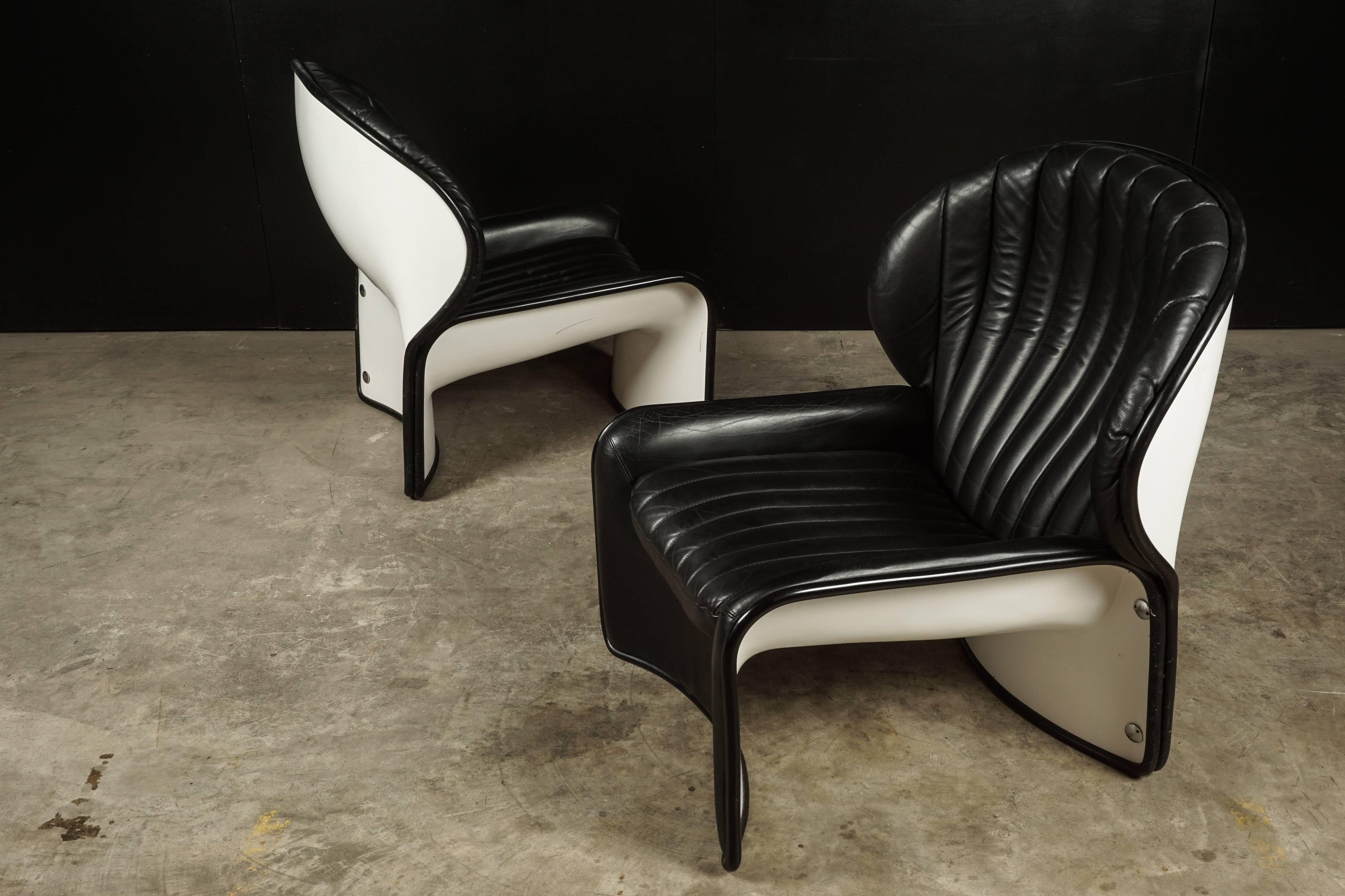 Pair of midcentury lounge chairs From Switzerland, circa 1970. Black stitched leather with a white fiberglass shell. Model 