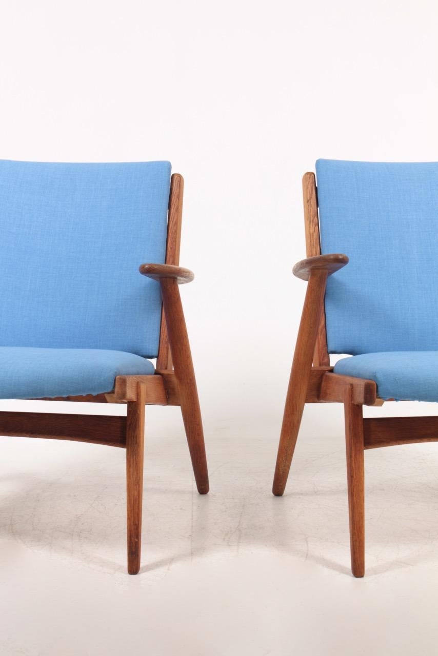Pair of lounge chairs in oil finished oak and fabric. Designed and made in Denmark. Great condition.