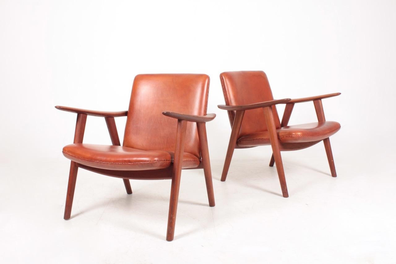 Pair of JH-517 lounge chairs in patinated leather and solid teak frame. Designed by Hans J. Wegner M.A.A for Johannes Hansen in 1951. Great condition. Made in Denmark.