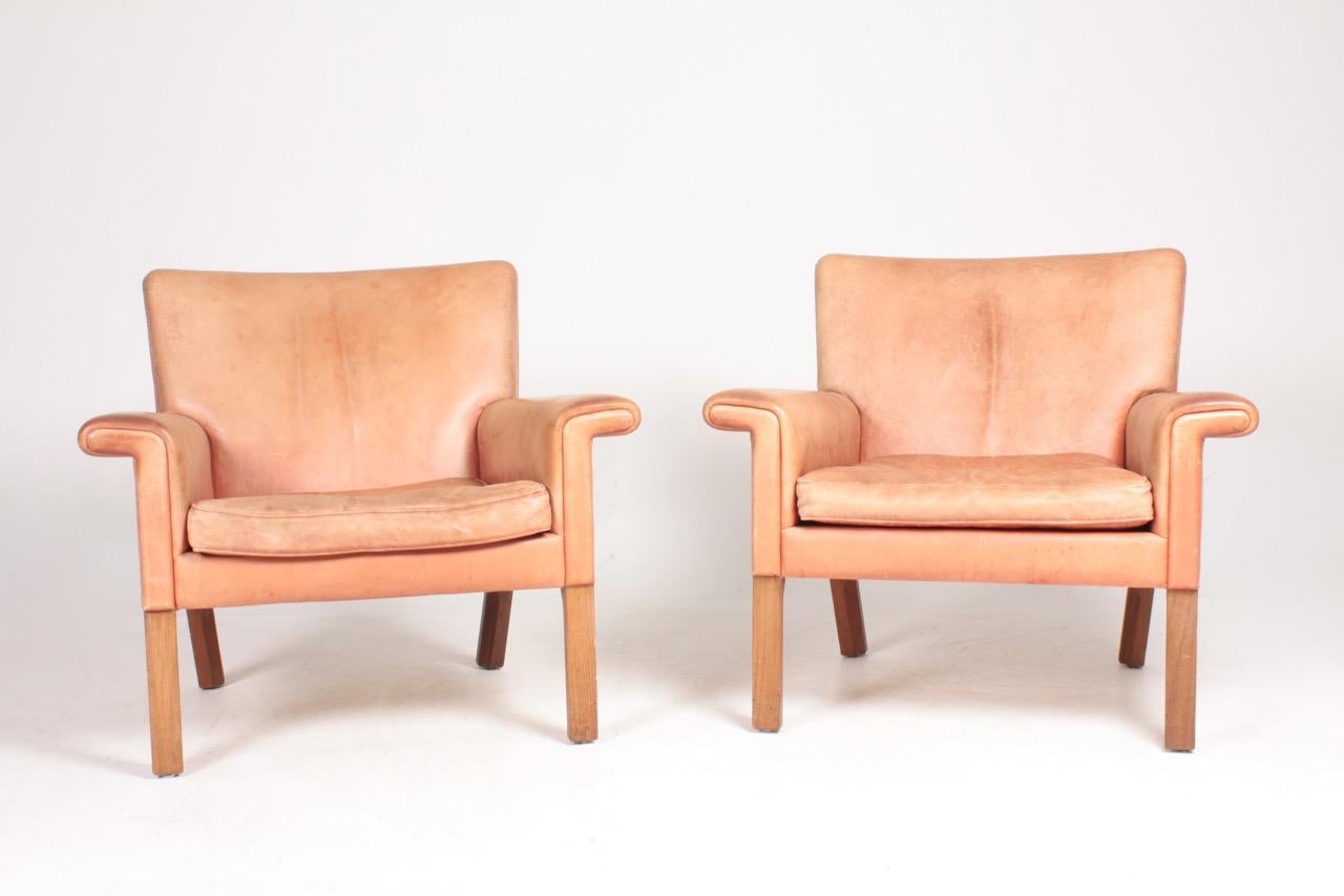Pair of AP 64 lounge chairs in patinated leather. Designed by Hans J. Wegner M.A.A for A.P in 1960s. Great condition. Made in Denmark.