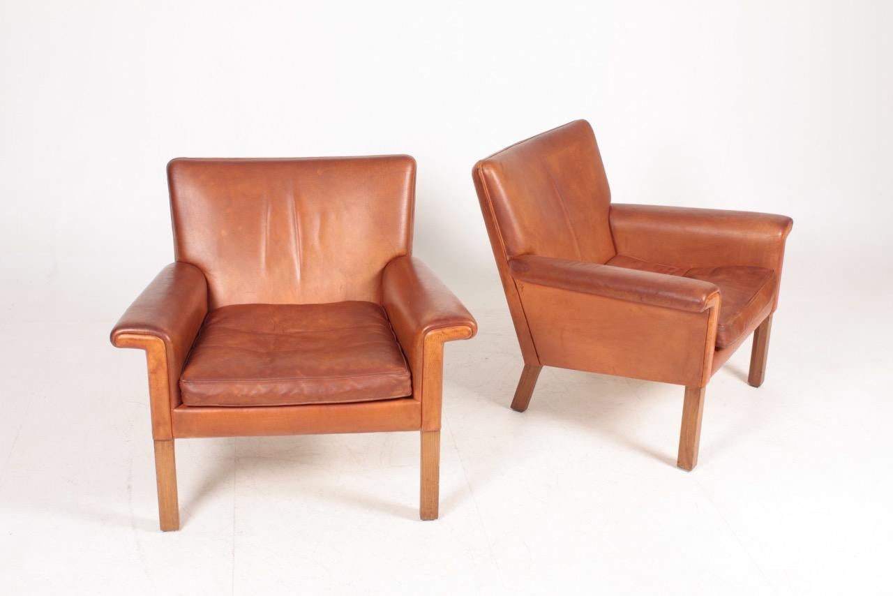 Pair of AP 64 lounge chairs in patinated leather. Designed by Hans J. Wegner M.A.A for A.P in 1960s. Great condition. Made in Denmark.