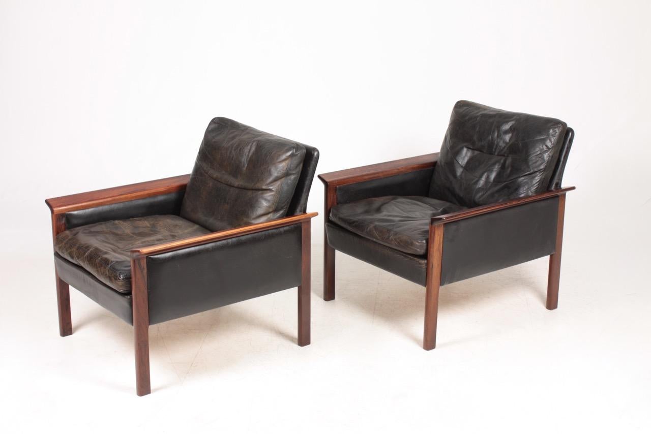 Pair of elegant Scandinavian lounge chairs in patinated black leather and rosewood. Great quality and design by Hans Olsen for CS Møbler. Made in Denmark in the 1960s.