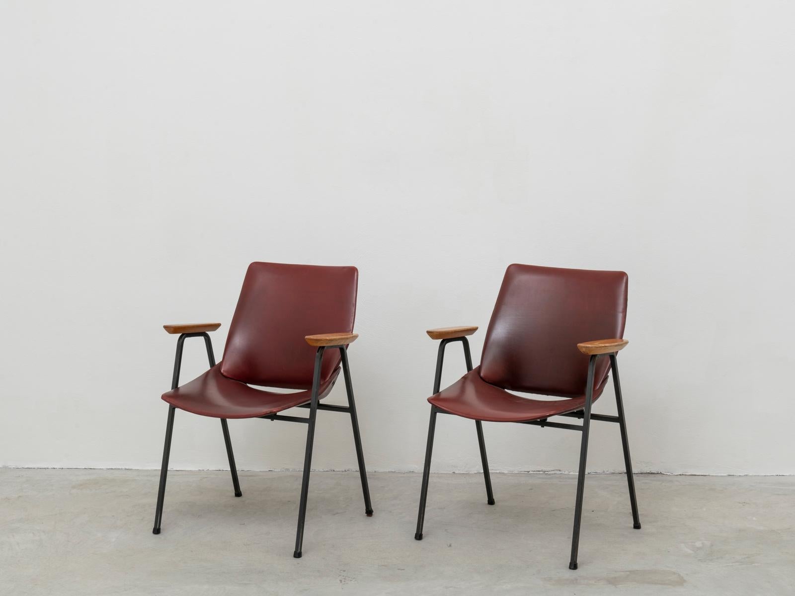 Pair of Mid-Century Modern armchairs were designed by Slovenian architect Niko Kralj. They were produced by the company Stol Kamnik from 1957. This pair is from circa 1960 and still features the original dark-cherry leatherette upholstering and