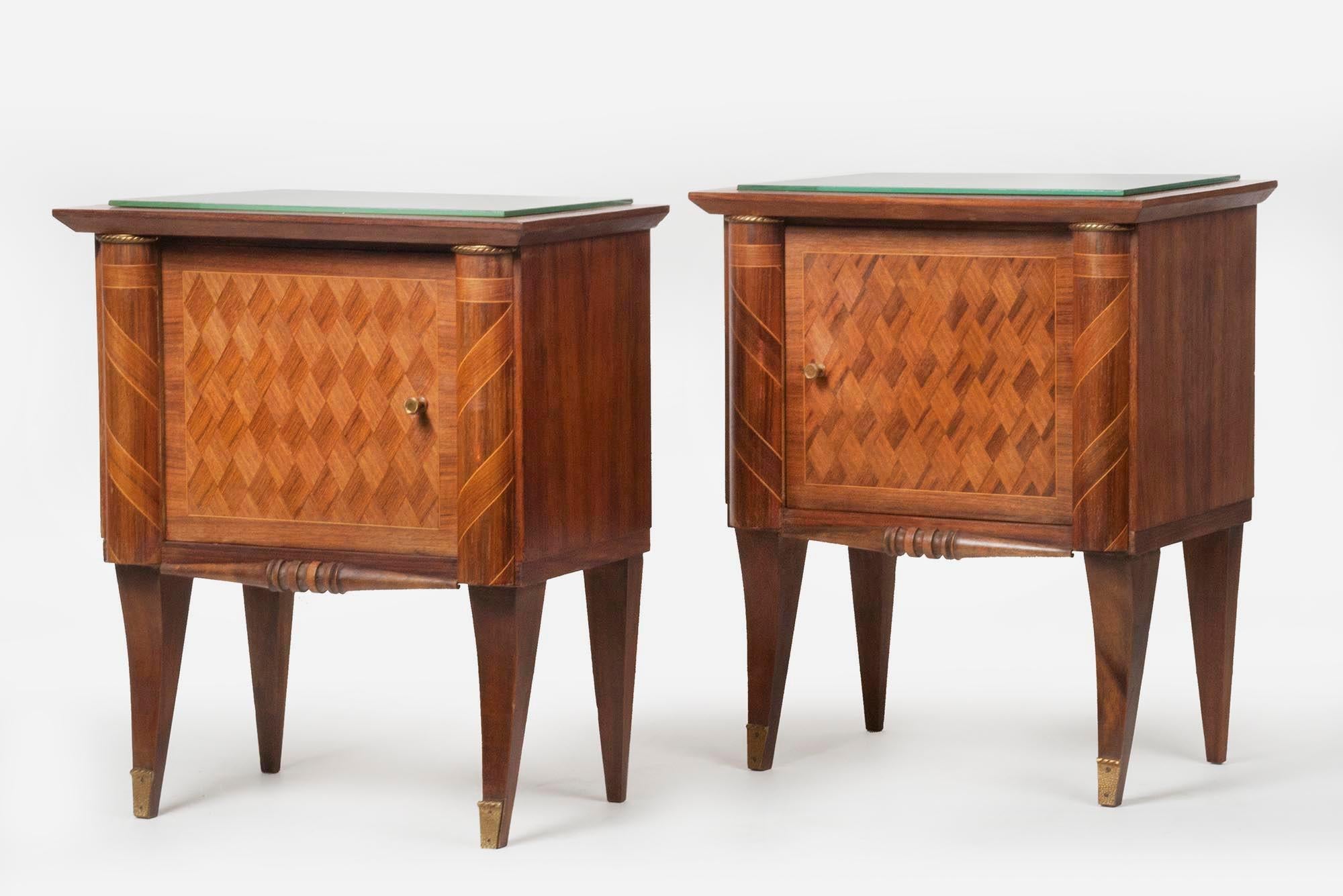 This pair of bedside tables was made in France, circa 1950. The legs have copper frames. The fronts are inlaid with marquetry. A mirror is attached to the top, this is the original.