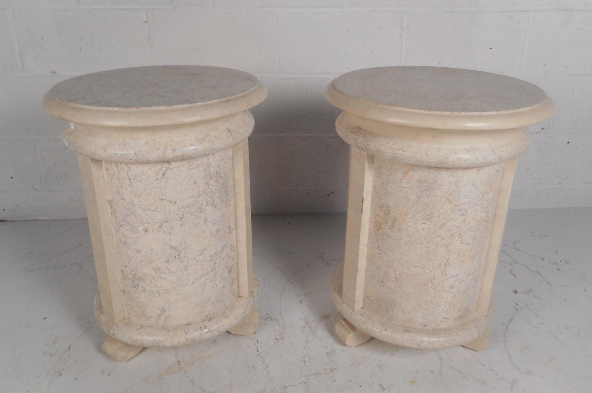 This wonderful pair of vintage modern tessellated stone end tables feature a cylindrical shape with sculpted feet on the base. This versatile pair of Maitland-Smith side tables or pedestal tables have a smooth rounded trim along the top. This