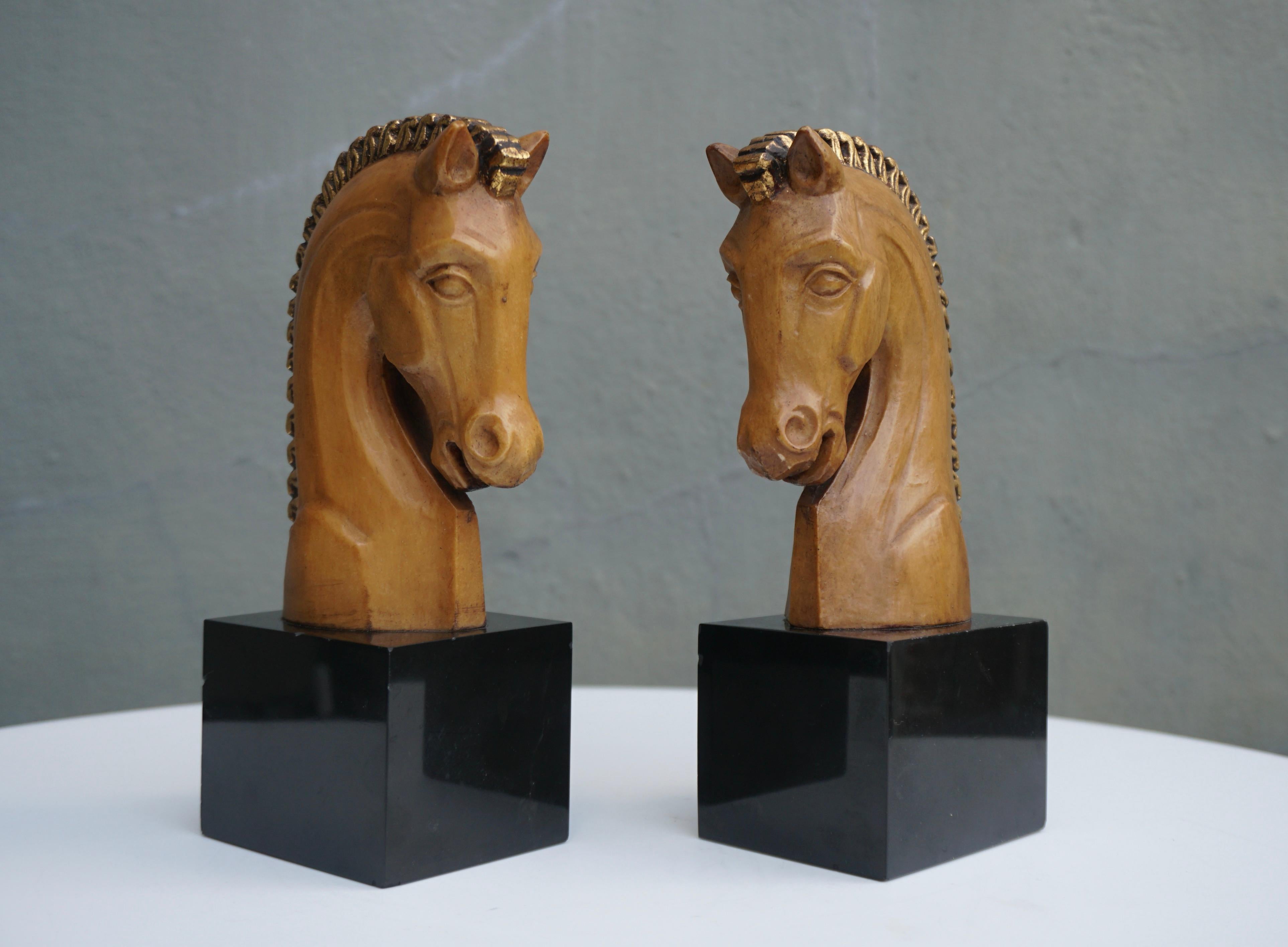 Stylish pair of midcentury wooden horse head bookends, circa 1970s. The bookends are heavy and well crafted, they are honey cream in color on a black marble base. Great addition to any office or den. 