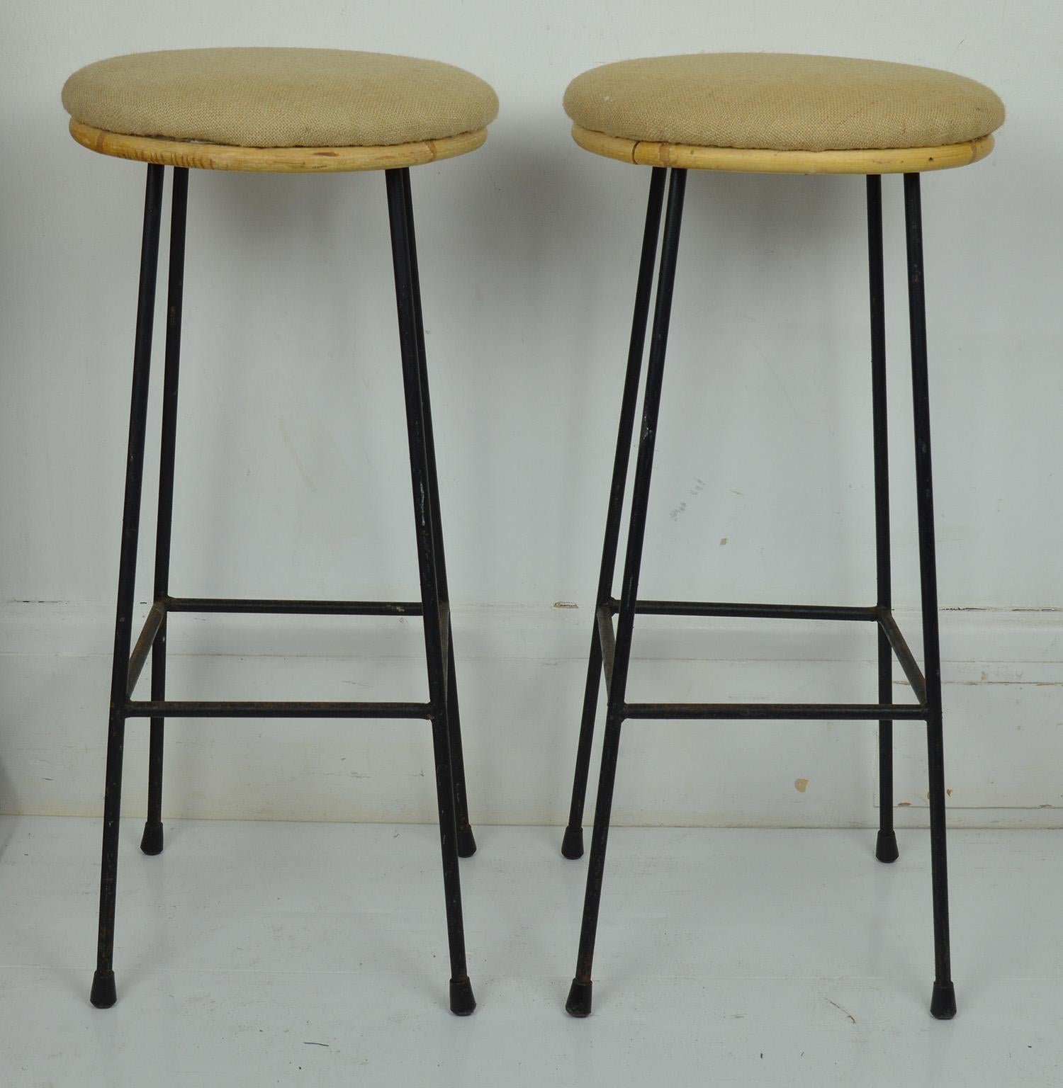 Wonderfully simple pair of wrought iron framed bar stools.

Designer unknown. Probably Italian.

Bamboo seats re-upholstered in burlap 

The original black painted metal parts showing signs of rust in places.
  