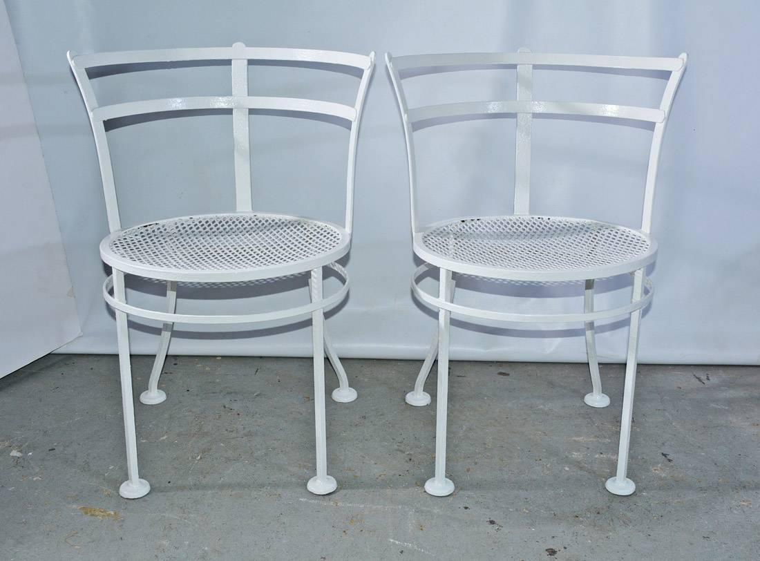 The pair of midcentury metal patio/garden chairs have rounded backs, mesh seats and a separate ring attached to the padded legs for additional sturdy support. The chairs are painted white. 

Measures: Seat height 17.25