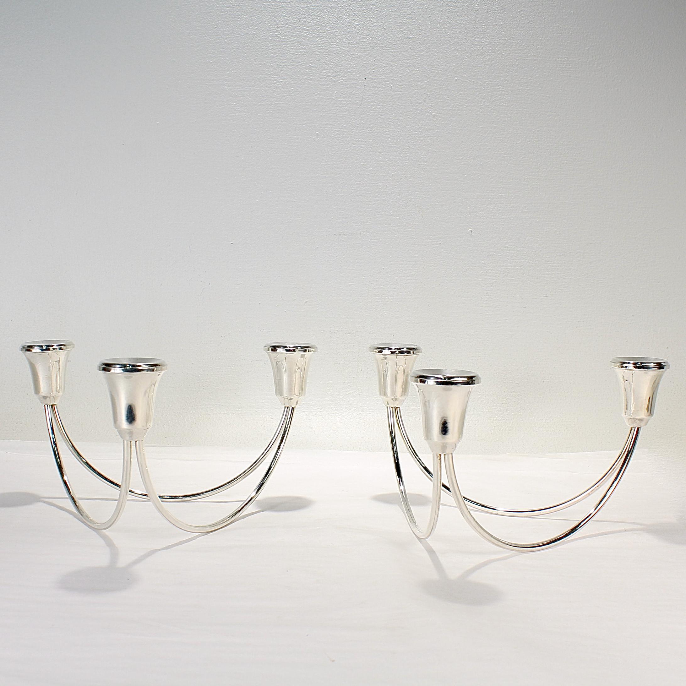 A fine pair of Mid Century Modern candelabra or candle holders.

In sterling silver. 

Each with 3 candle cups connected by two sterling silver rounded rods. 

Perfect for the modern table!

Date:
20th Century

Overall Condition:
It is in overall