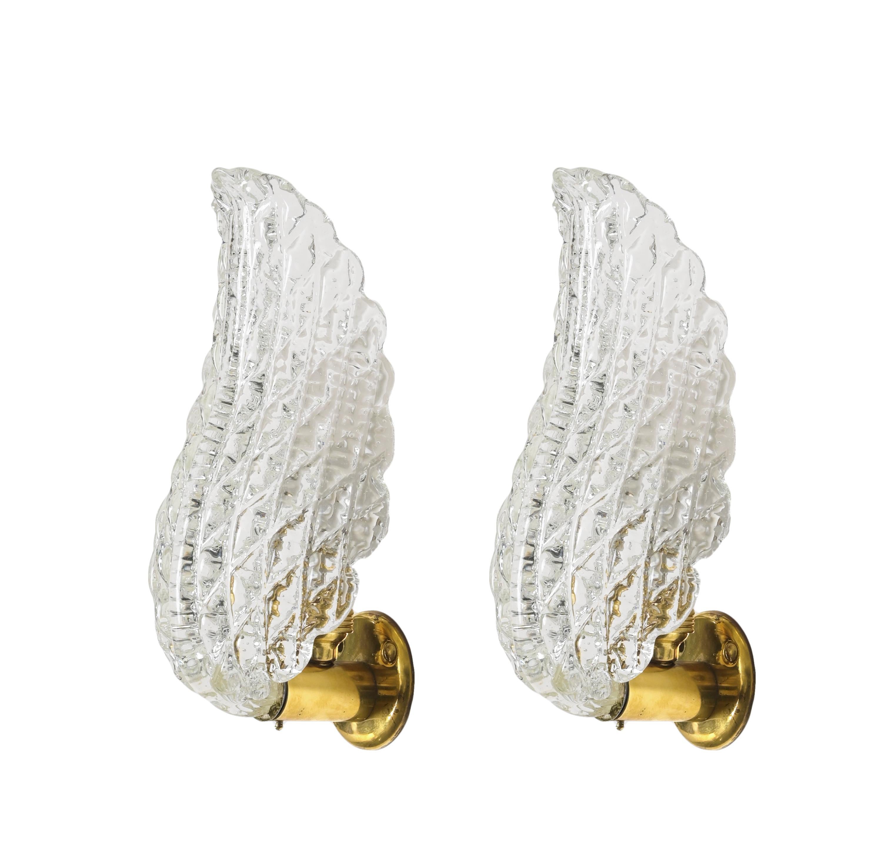 Magnificent pair of mid-century leaf sconces in Murano hand-blown crystal glass and solid brass. These wonderful lights were designed in Italy by Barovier in the 1950s.

These finely crafted Murano sconces recall the the shape of a leaf, with