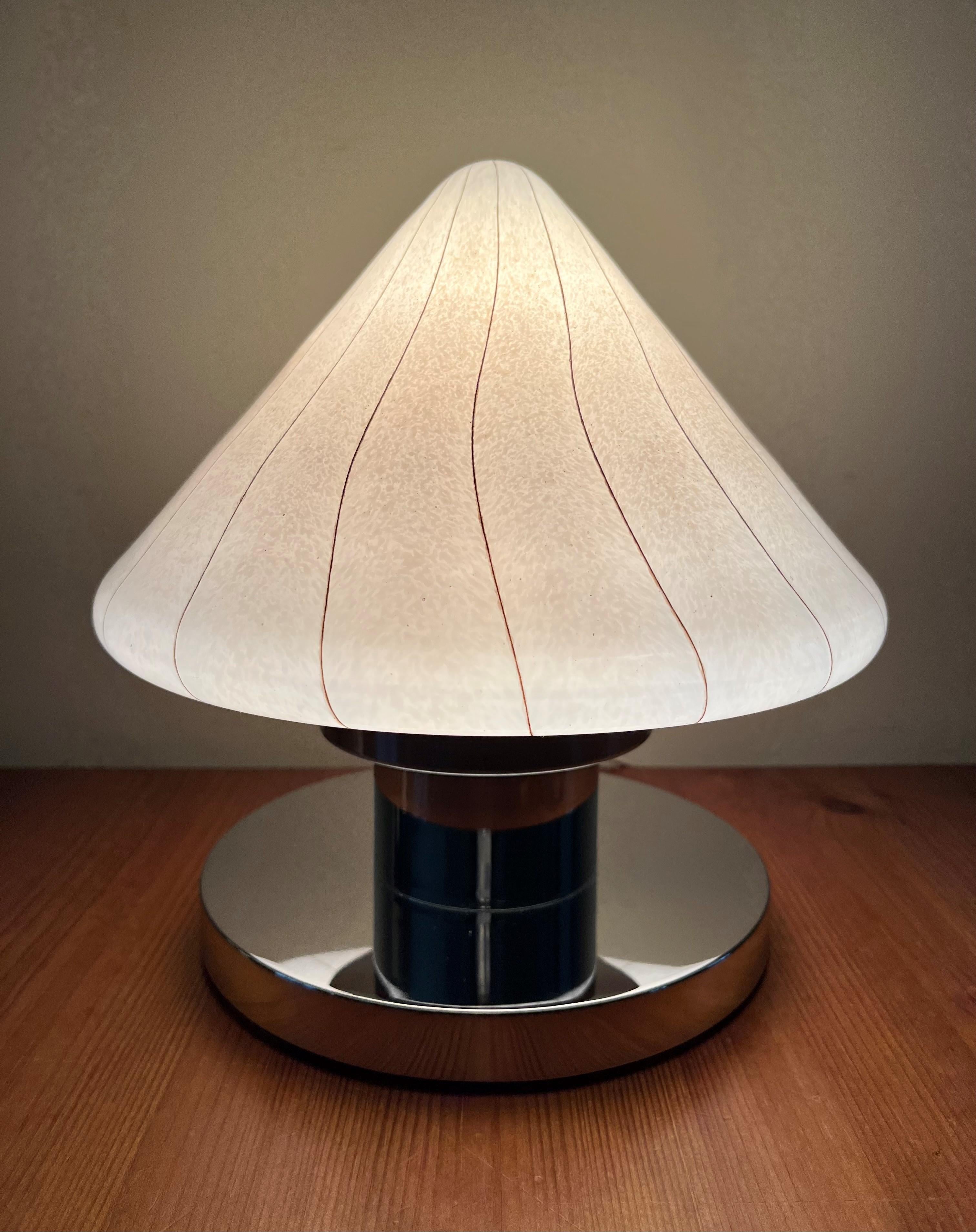 Charming, refined and lovely set of two Italian Murano table lamps. These table lamps were made during the 1970s in Italy. Original sticker label still shows on structure of table lamp.
Each table lamp is composed chromed metal structure and a
