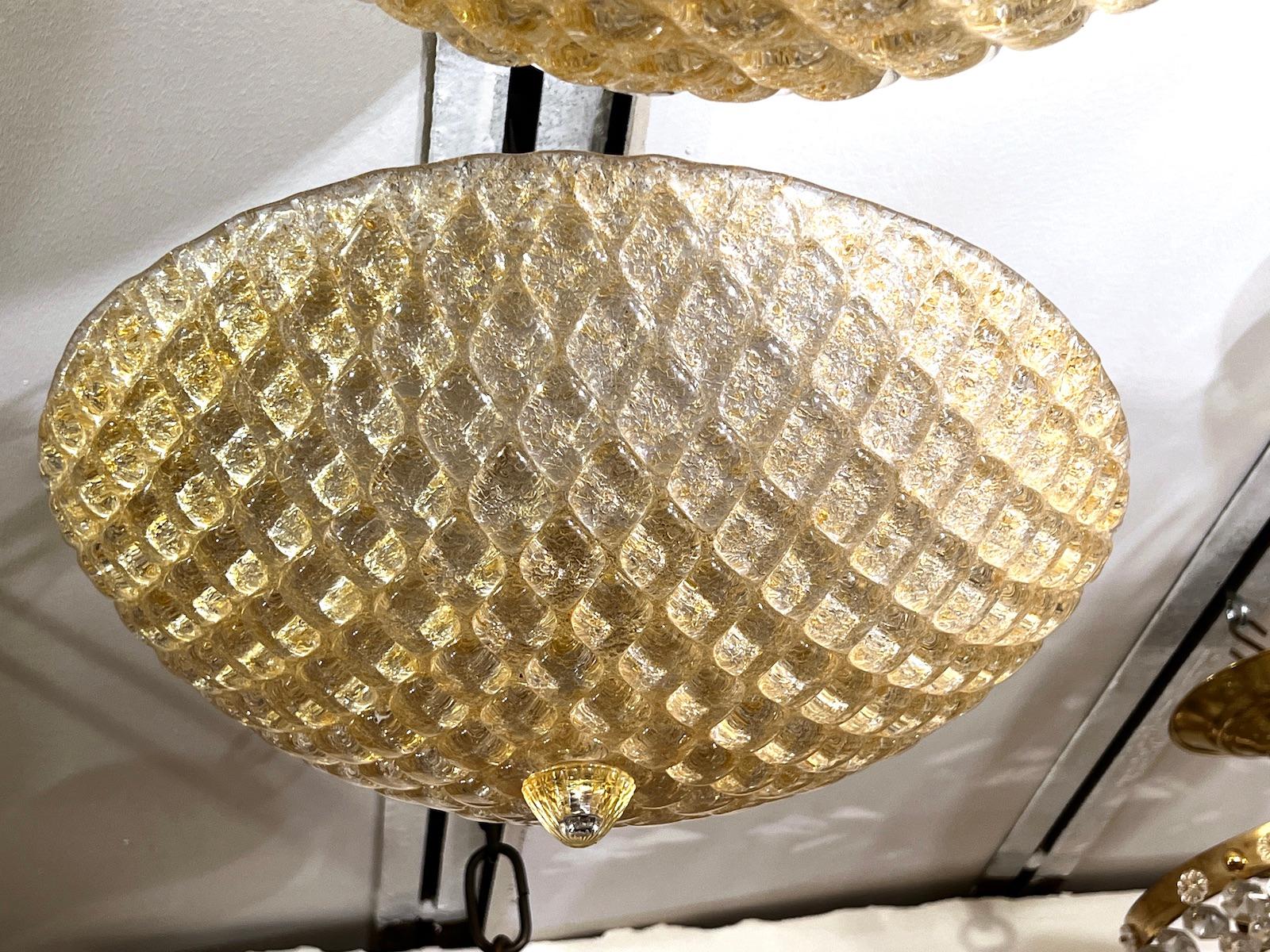 A pair midcentury gold-tone Murano glass light fixtures with ‘quilted’ texture. Sold individually.

Measurements:
Drop: 10?
Diameter: 16?.