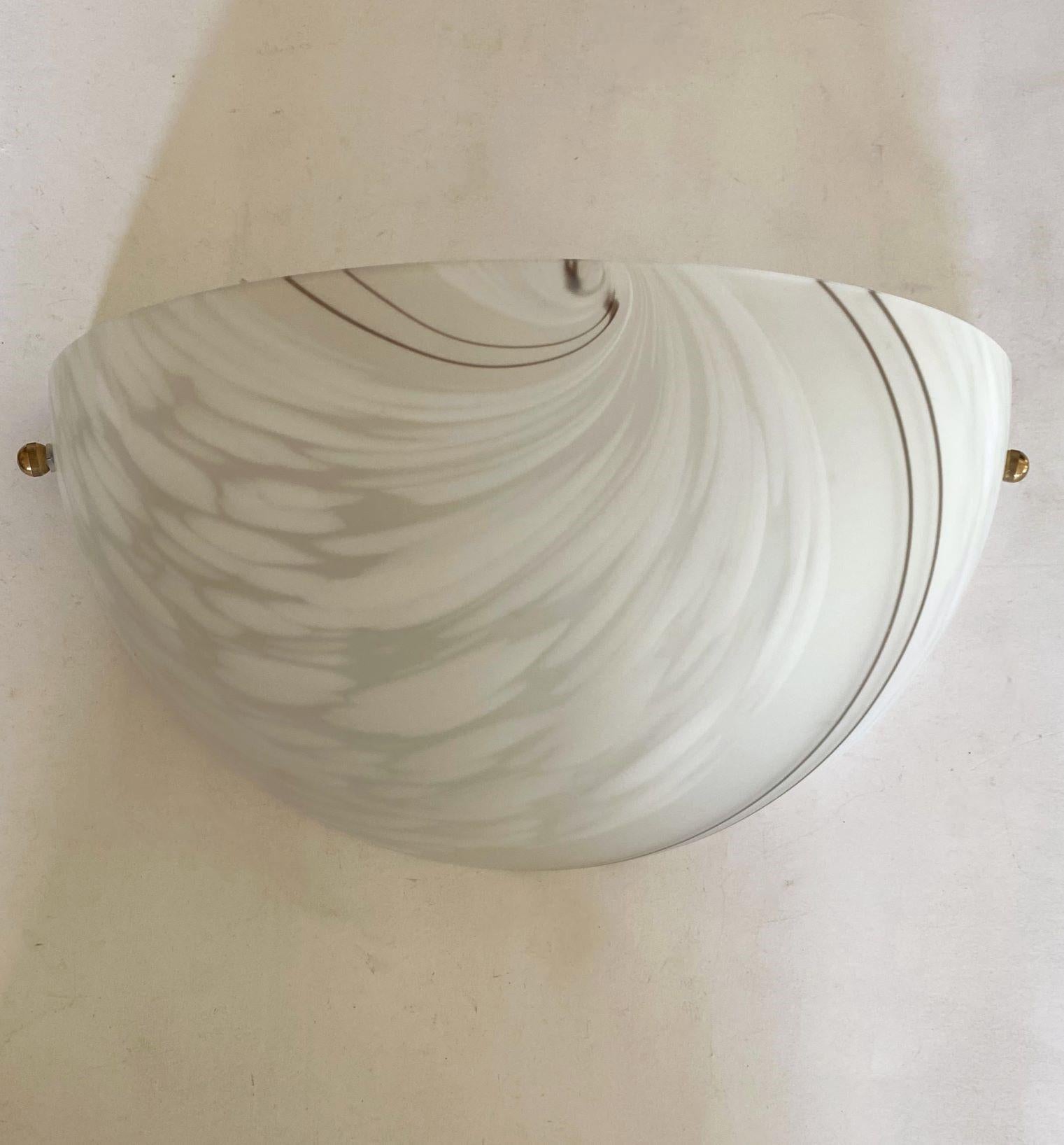 Pareja de apliques de cristal de Murano de mediados de siglo, Italia, años 60. Vidrio de murano artístico en forma de media luna con motivos geométricos. Cada aplique admite una bombilla con casquillo de rosca E27 que crea una luz cálida y agradable