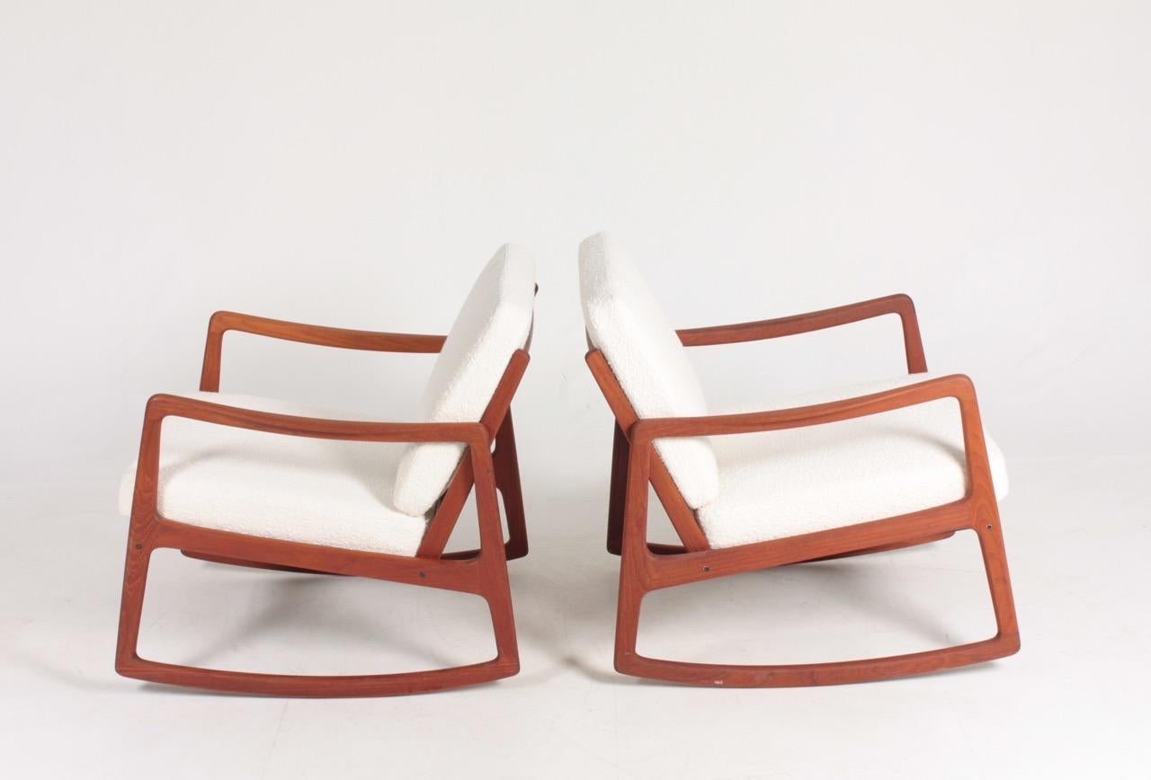 Pair of rocking chairs in solid teak, upholstered in bouclé. Designed by Ole Wanscher, made by France & Son in the 1960s. Great condition.