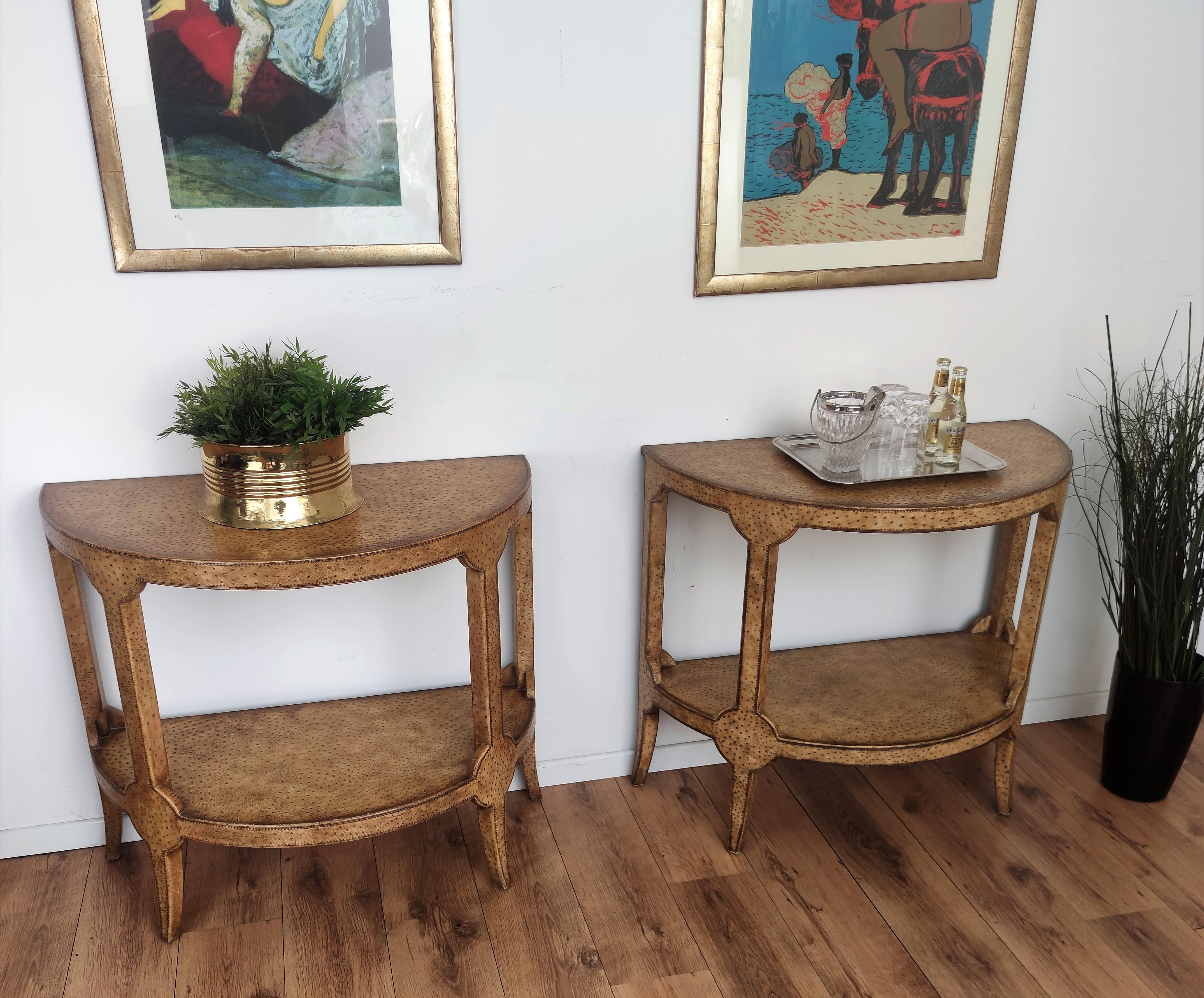 Very elegant pair of two-tiered mid-century consoles tables with a modern take on a neoclassic demi-lune form covered in beautiful ostrich leather.