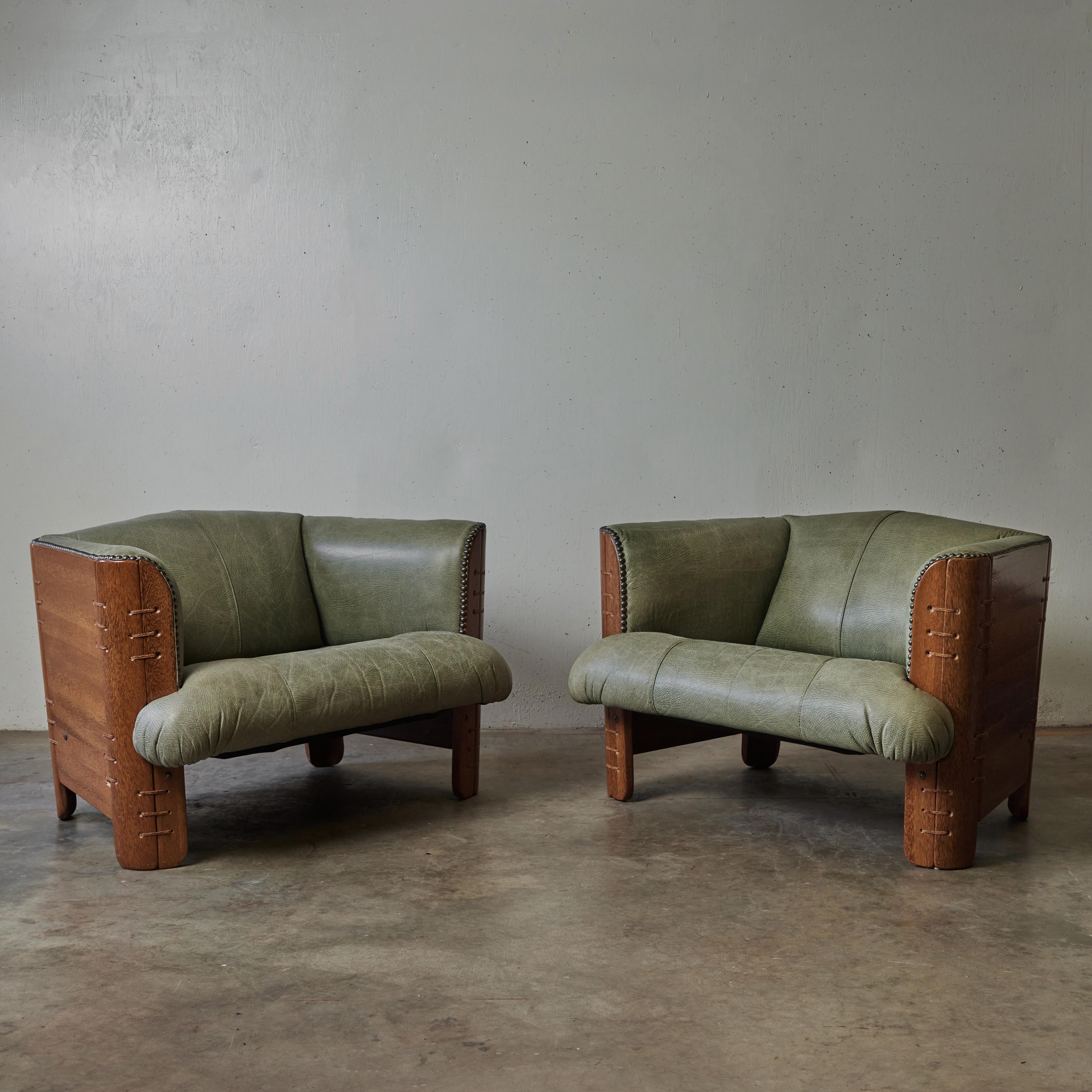Gorgeous pair of mid-century chairs in palmwood (a sustainable alternative to tropical hardwood) with the original textured celadon green leather upholstery, designed by Pacific Green. Chic and statement-making yet with an easy, relaxed sensibility,