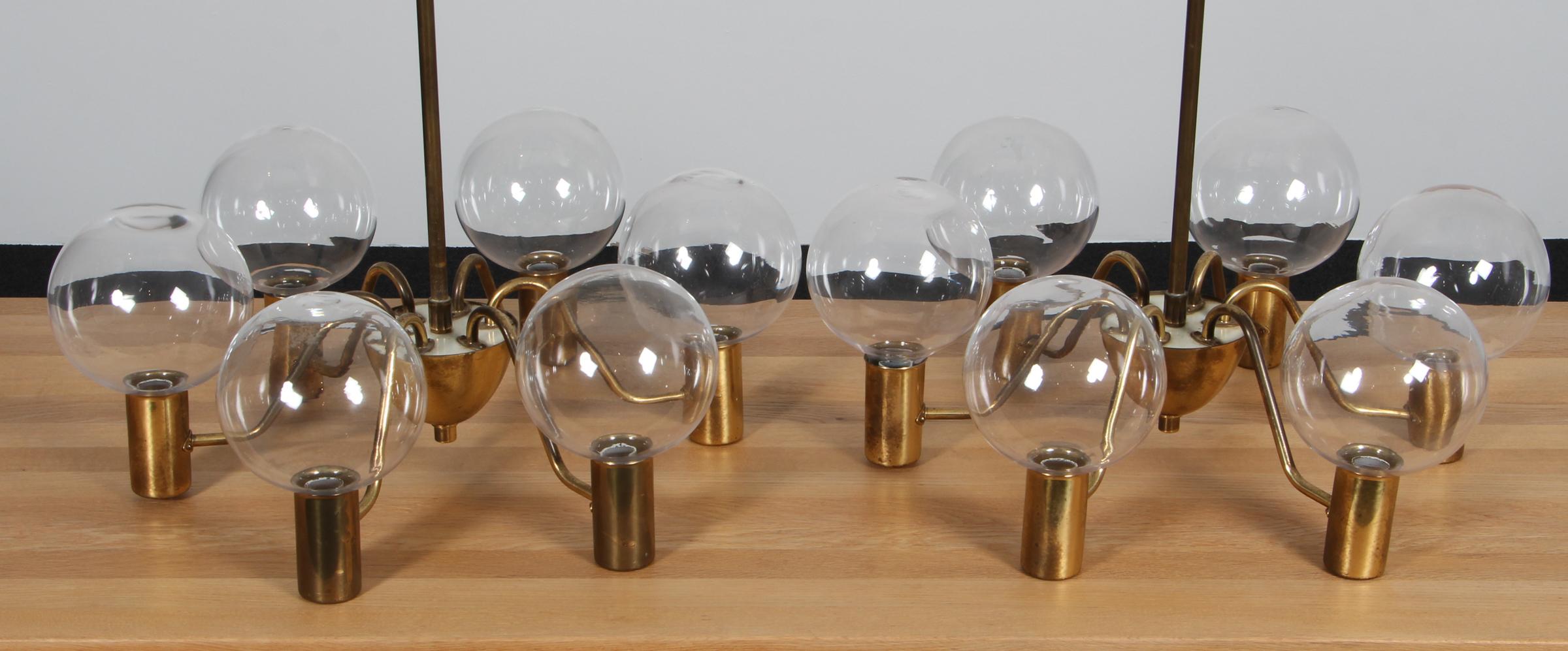 Coppia di lampadari a sei braccia in ottone e vetro trasparente disegnati da Hans/One Jacobsen e realizzati da AB Markaryd in Svezia. Ottime condizioni originali.

