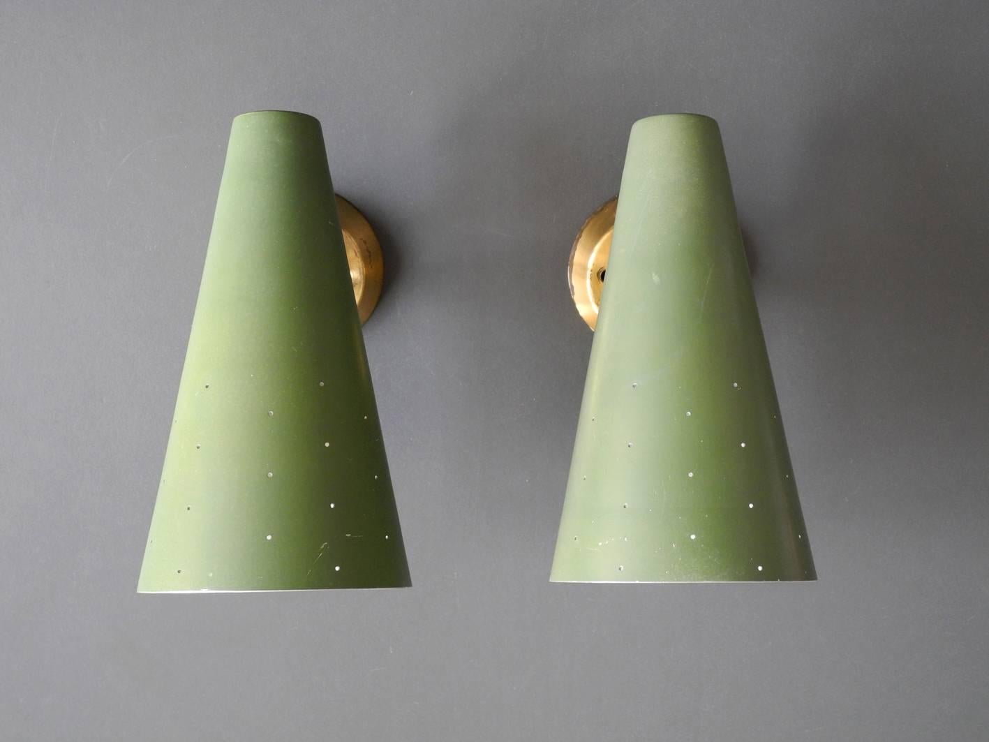 A pair of very elegant Italian midcentury cone lamps made of perforated metal.
Base is made of brass, cones are made of aluminum. Steplessly movable at the joint. Beautiful minimalistic Italian design for a very pleasant light.
Outside the shade