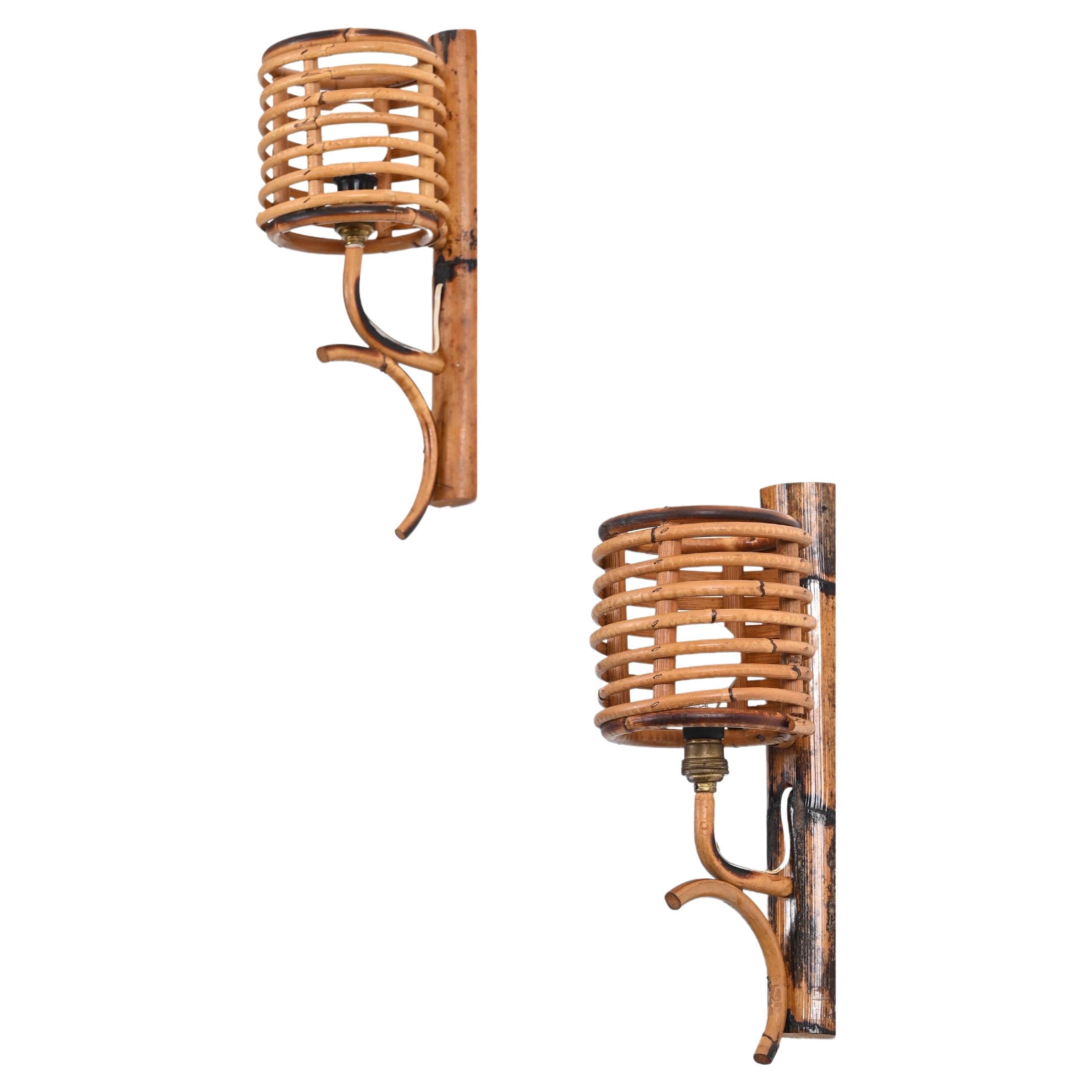 Lovely pair of midcentury wall lamps in rattan and bamboo. These fantastic lamps were produced in the 1960s in France and are attributed to Louis Sognot. 

The sconces feature a beautiful spiral-shaped shade in curved rattan. A great example of
