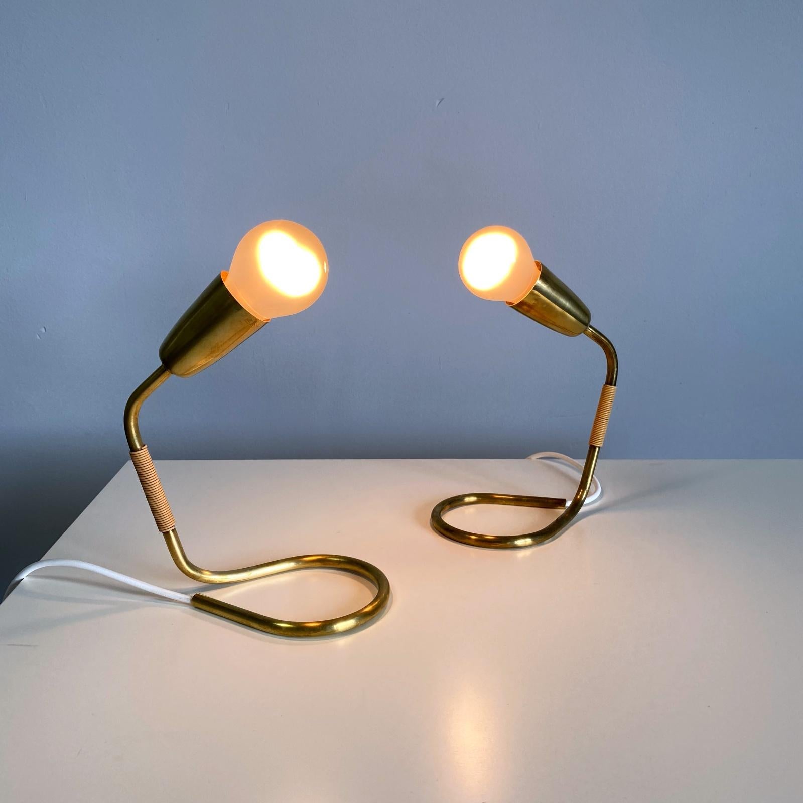 Zwei elegante Nachttisch- oder Tischlampen aus poliertem Messing von Rupert Nikoll. Hergestellt aus gebogenem Messingrohr.
Voll funktionsfähiger, neu verkabelter und geprüfter Zustand mit schöner Patina. Eine Edison E27-Fassung. Die Lampen