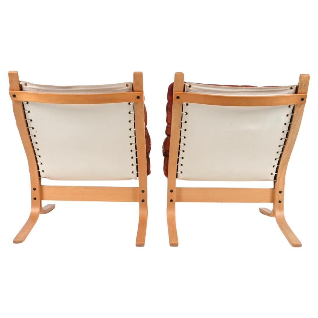 Pair of Midcentury Scandinavian Modern leather low lounge chairs by Westnofa.

(2) Westnofa Norwegian modern low Siesta chairs designed by Ingmar Relling. Blonde beech Wooden frames, beautiful red leather cushions. Bentwood frames and white cloth