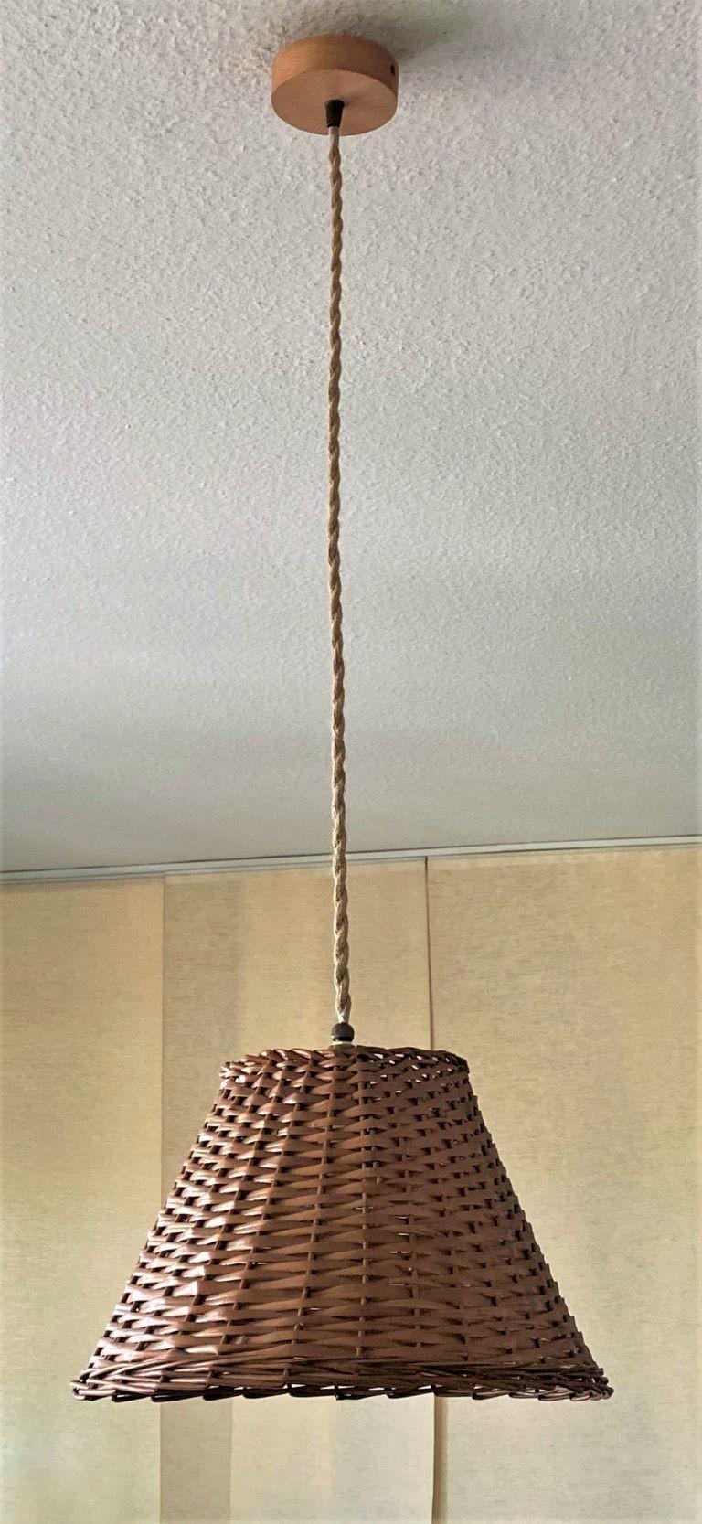 Un delizioso ciondolo in rattan del Midcentury, Danimarca, anni '60. Questa bellissima lampada a sospensione è realizzata a mano in rattan, con paralume e baldacchino in legno. Con portalampada singolo in ottone e porcellana per una lampadina a vite