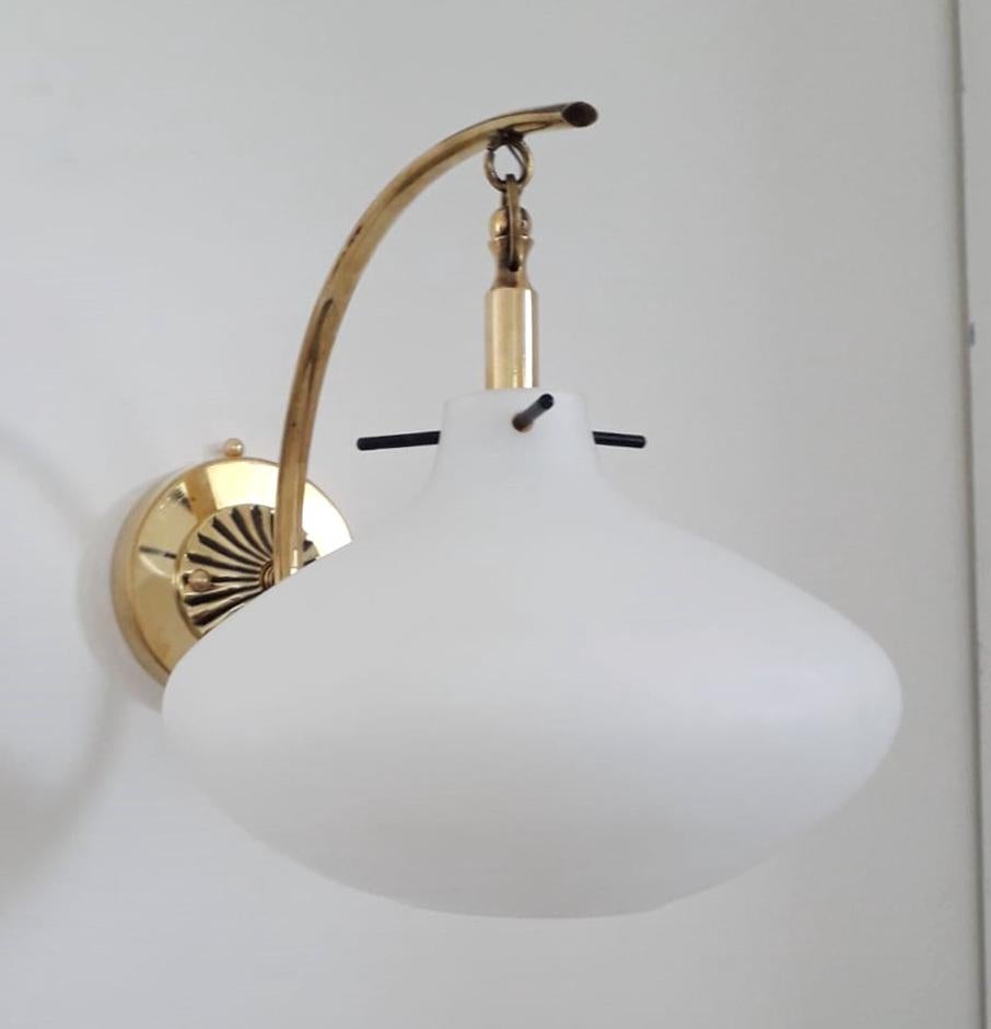 Vintage Italian wall lights with large pear shaped opaline glass diffusers suspended from curved brass frames resembling lanterns / Made in Italy by Stilnovo, circa 1950s.
Measures: height 9.5 inches, width 8 inches, depth 14 inches
1 light / E12