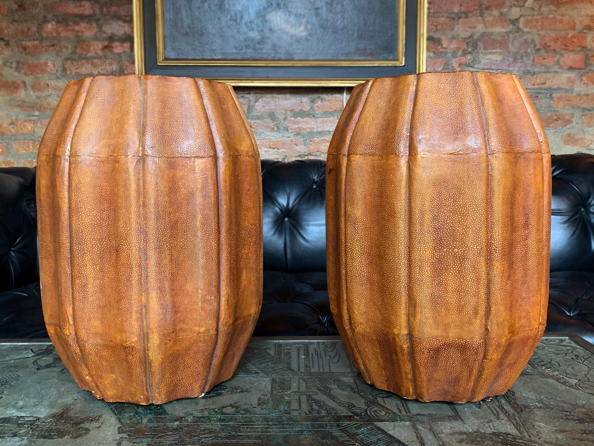 A pair of mid-20th century stools in the style of Karl Springer. Comprised of wood with shagreen wrap and black lacquered undersides. They have a very textured surface and an organic shape reminiscent of an orange squash with a flattened top and