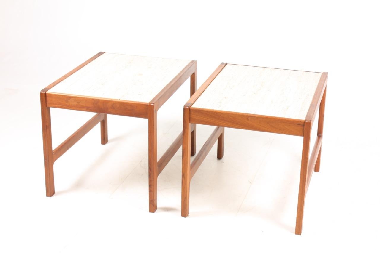 A pair of side tables with travertine top on a solid teak frame. Sold by Illums Bolighus in 1960s, Denmark. Great original condition.