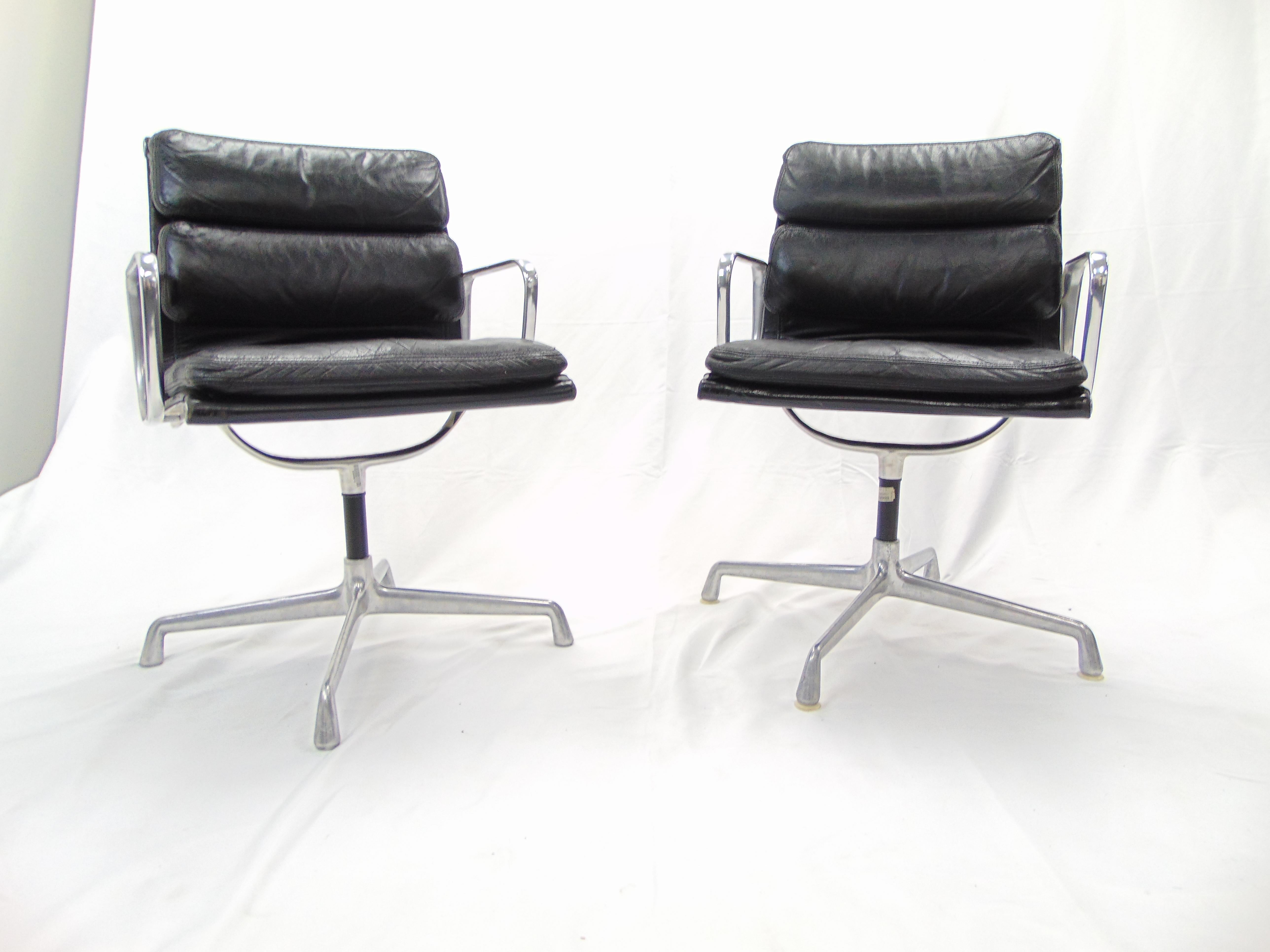 These are a pair of wonderful vintage midcentury chairs from the 1970s designed by Charles and Ray Eames for Herman Miller. The chairs are aluminum and black leather. One of the chairs has the plastic feet on it and the other does not. One chair had